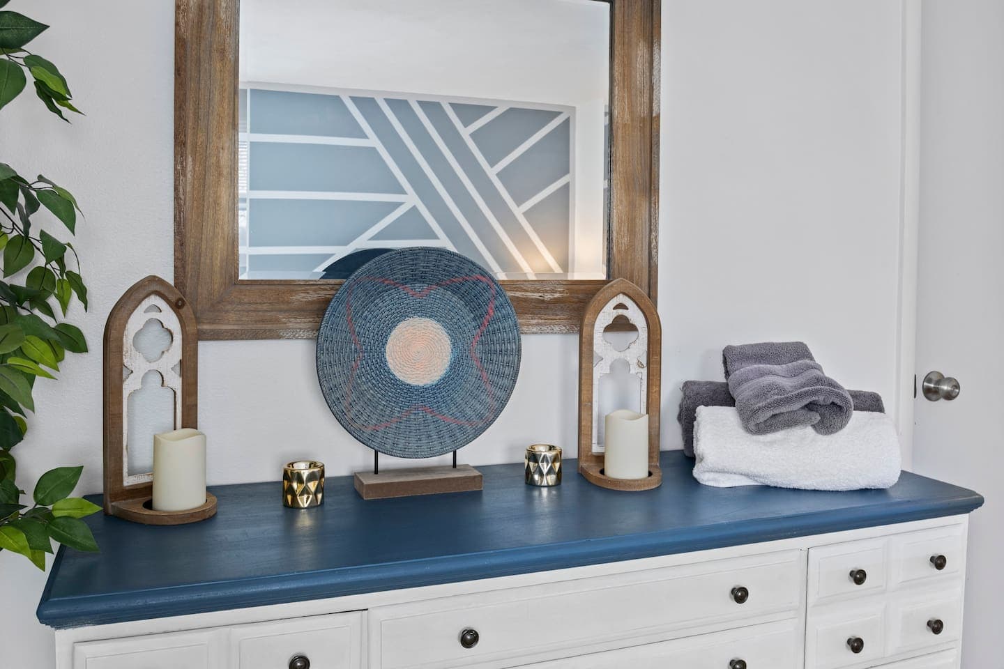 Blue vanity beneath a round mirror
