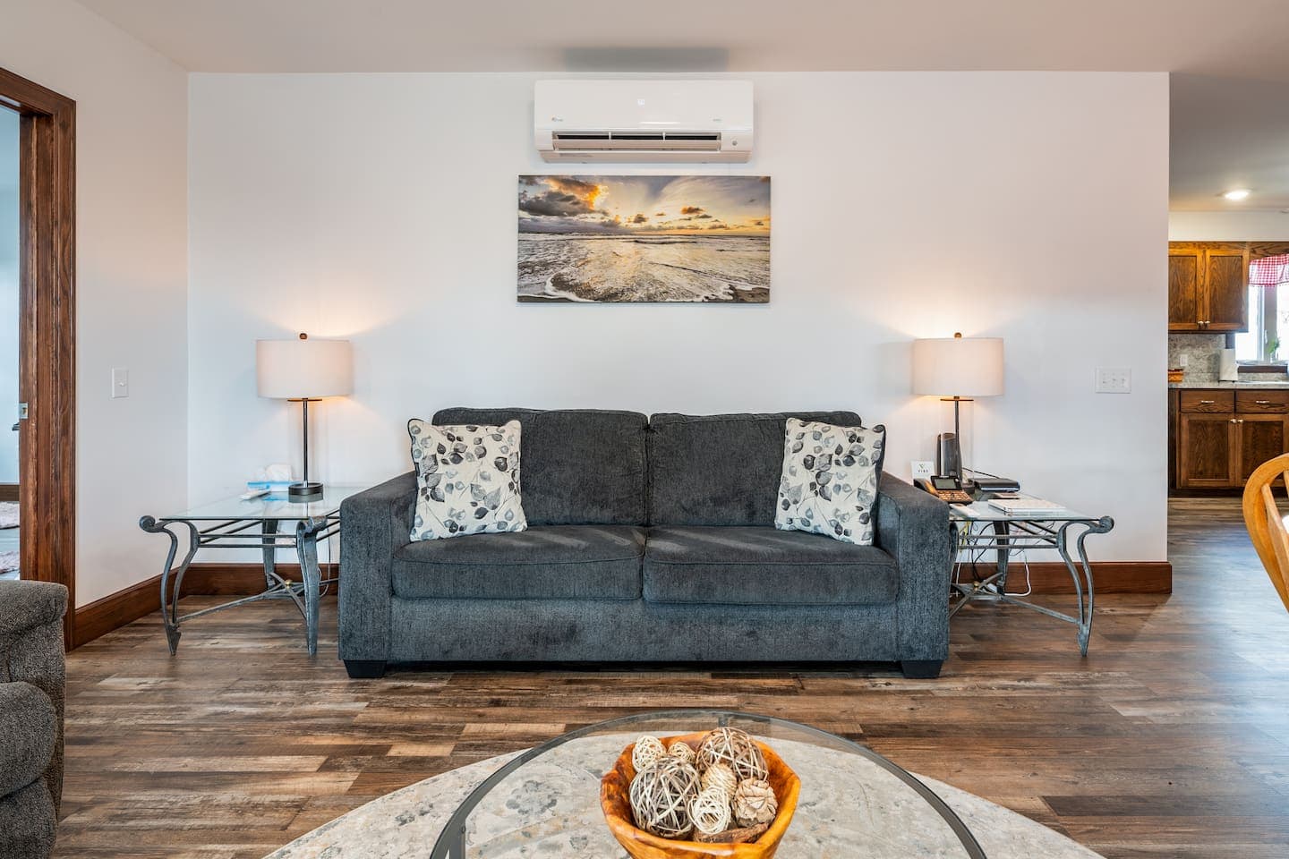 Sofa seating beneath framed landscape artwork