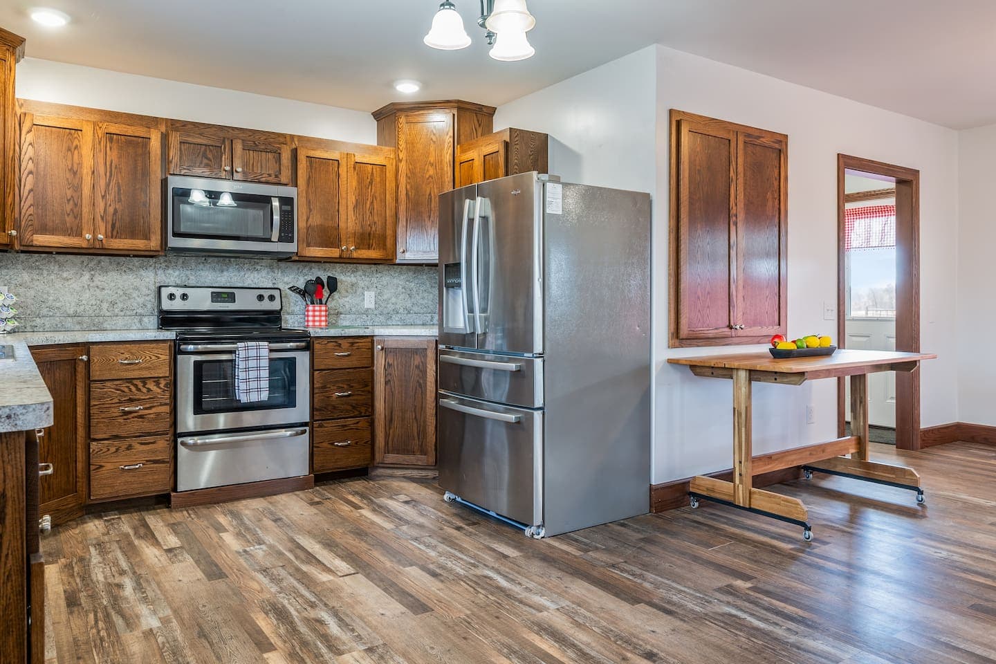 Stainless refrigerator beside built-in ovens