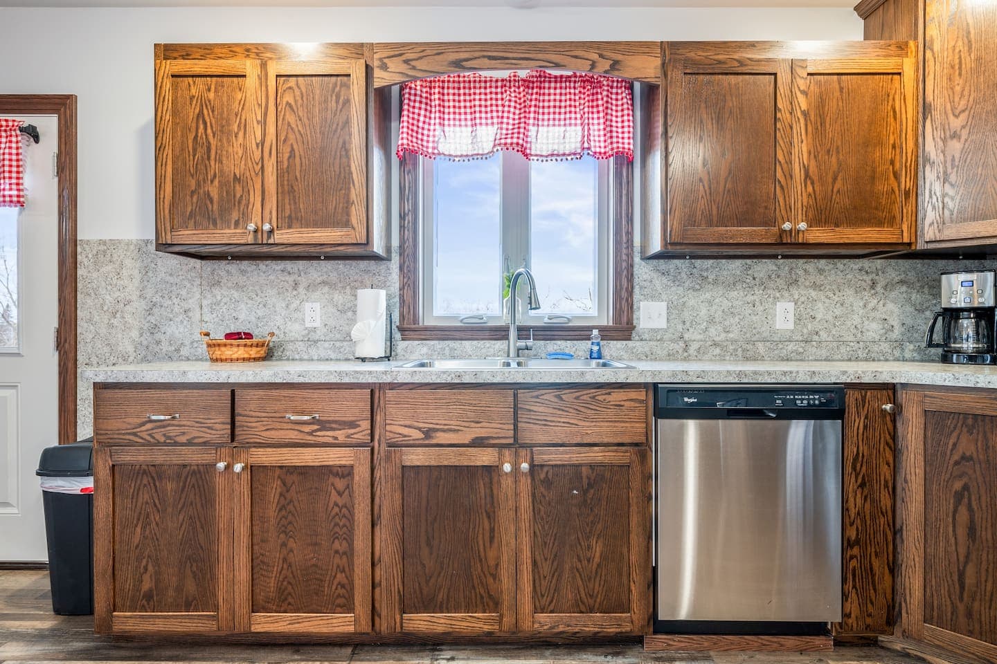 Kitchen sink beneath red-trimmed windows