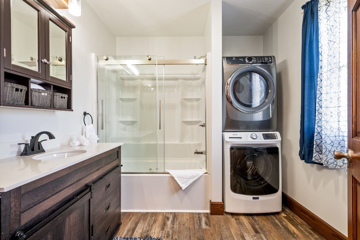 Stacked washer and dryer beside shower
