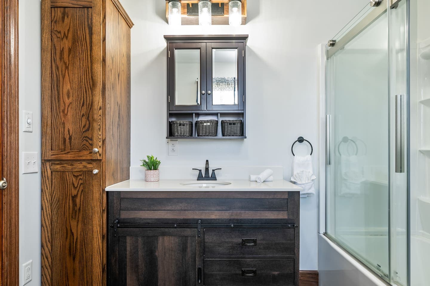 Bathroom vanity with wooden cabinetry and mirror