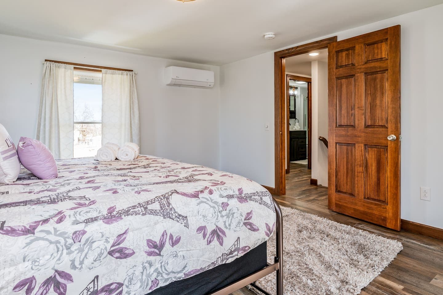 Bedroom with floral bedding and wood furniture