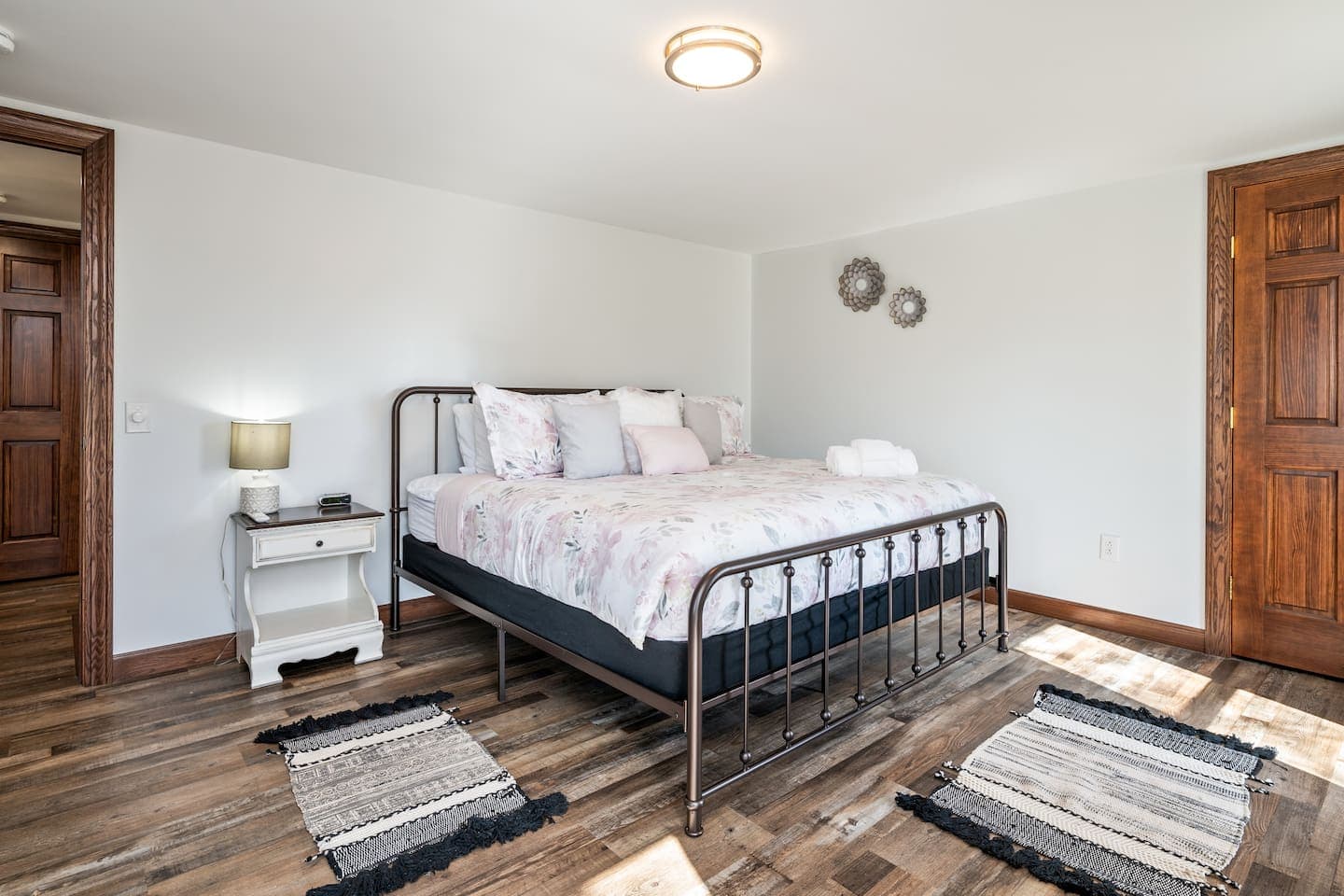 Bedroom with white bedding and wood dresser