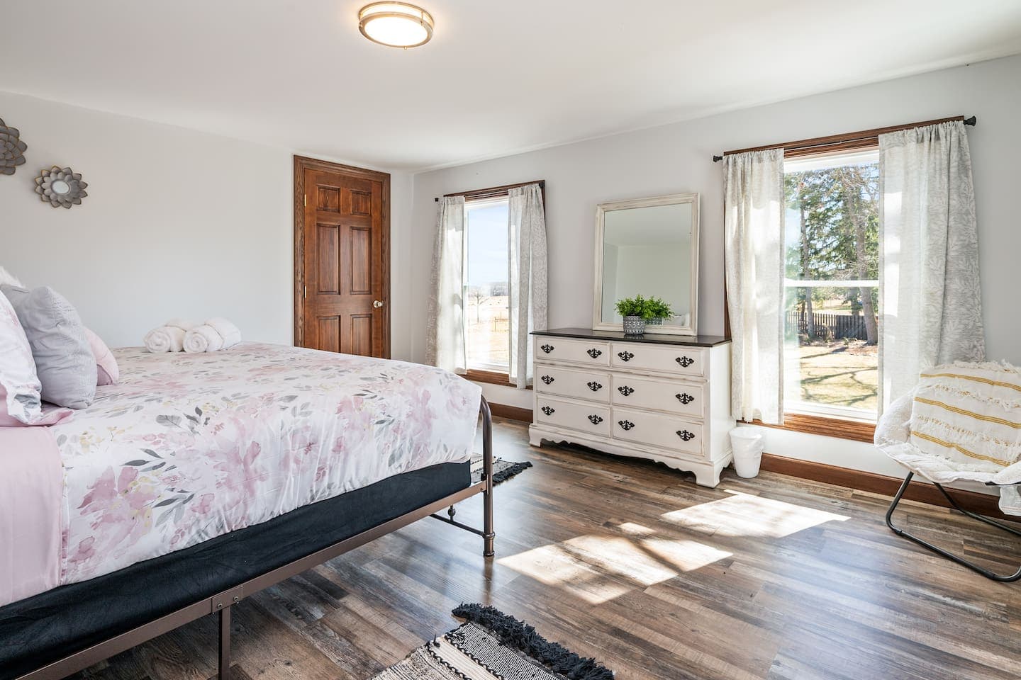 Bedroom with floral bedspread and two windows