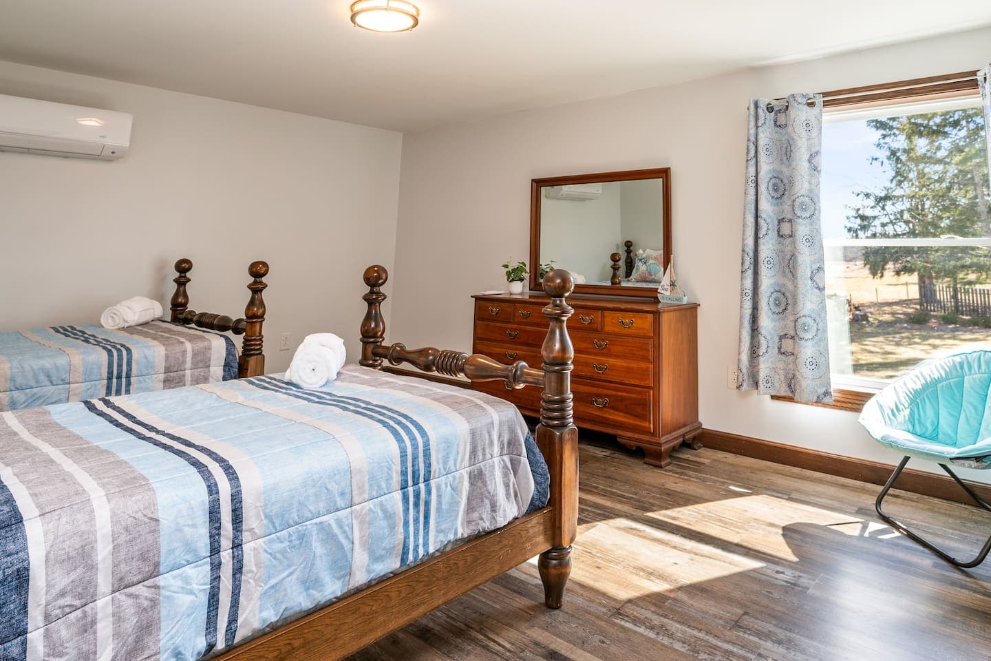 Bedroom with two wooden beds and striped linens