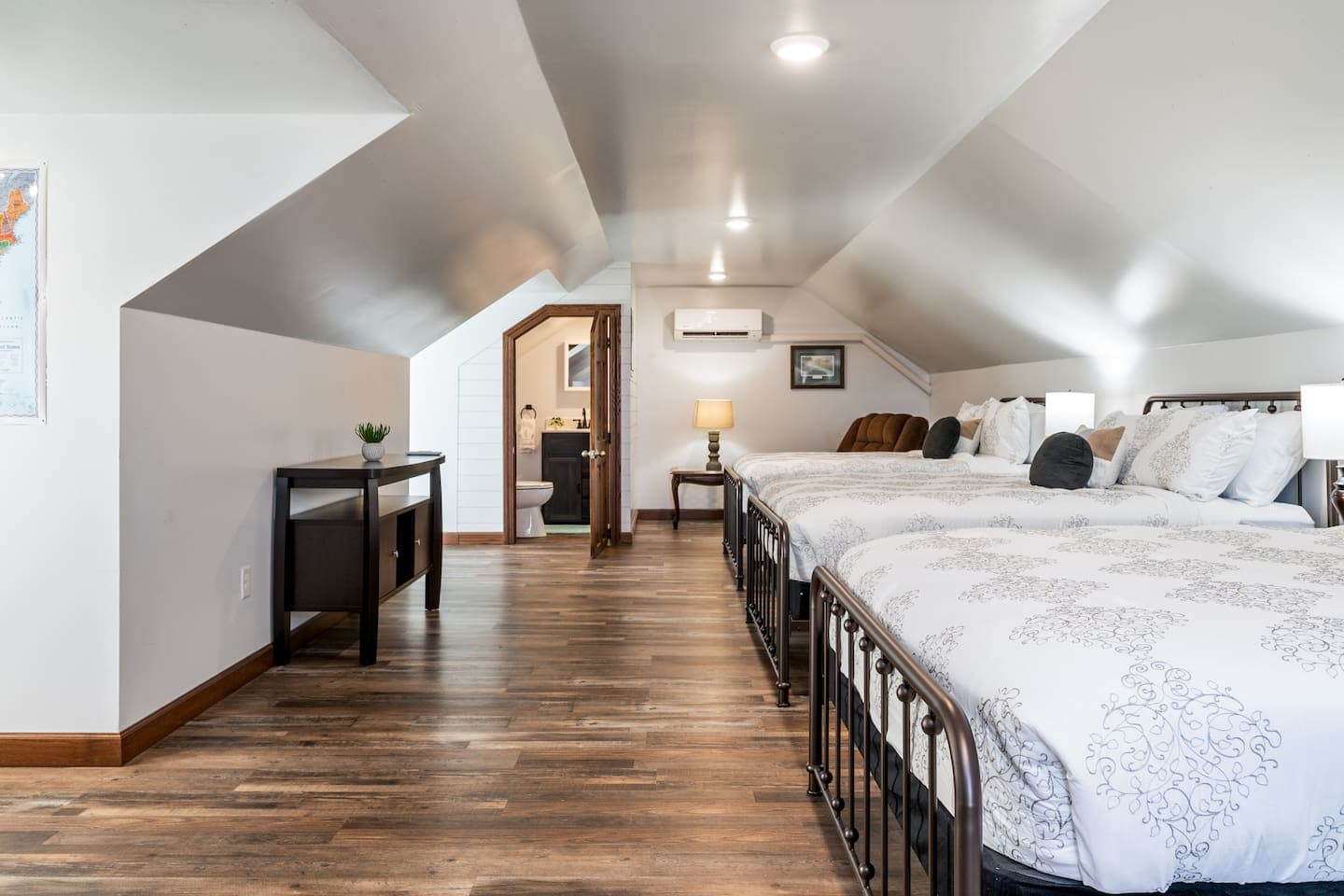 Room with multiple beds beneath sloped ceilings