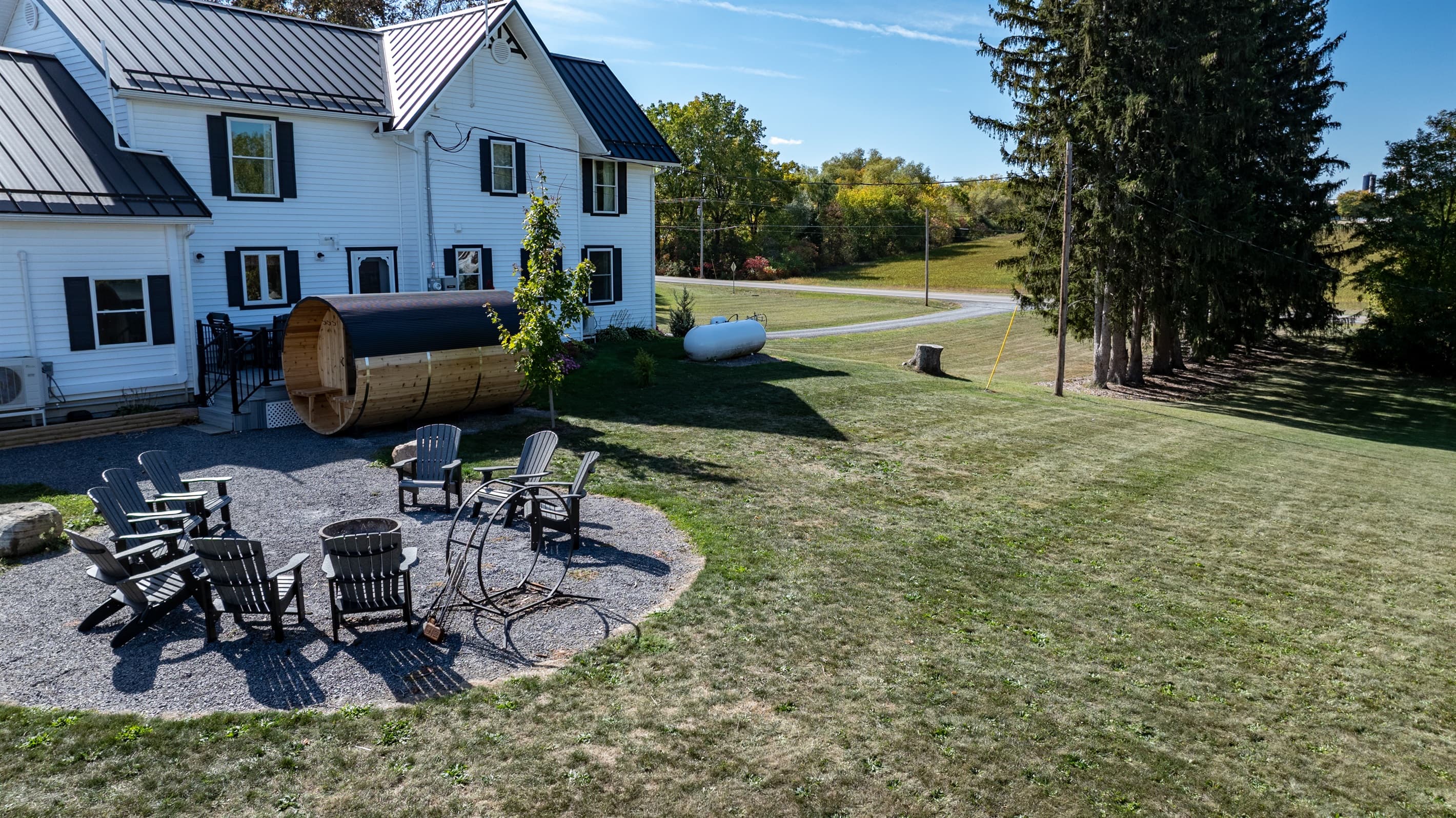Backyard with outdoor seating area and barrel sauna