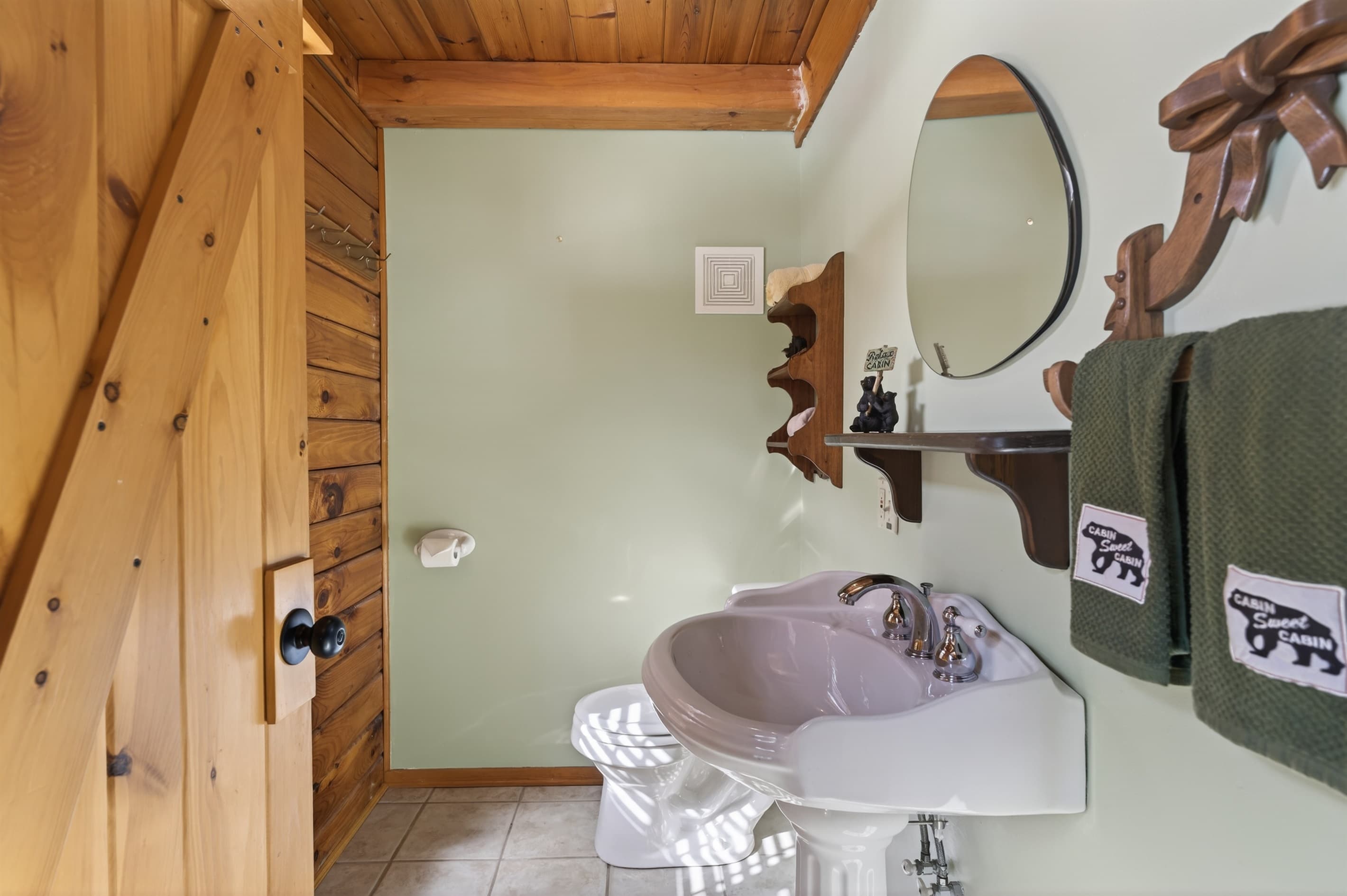 Half bathroom with pedestal sink and mirror