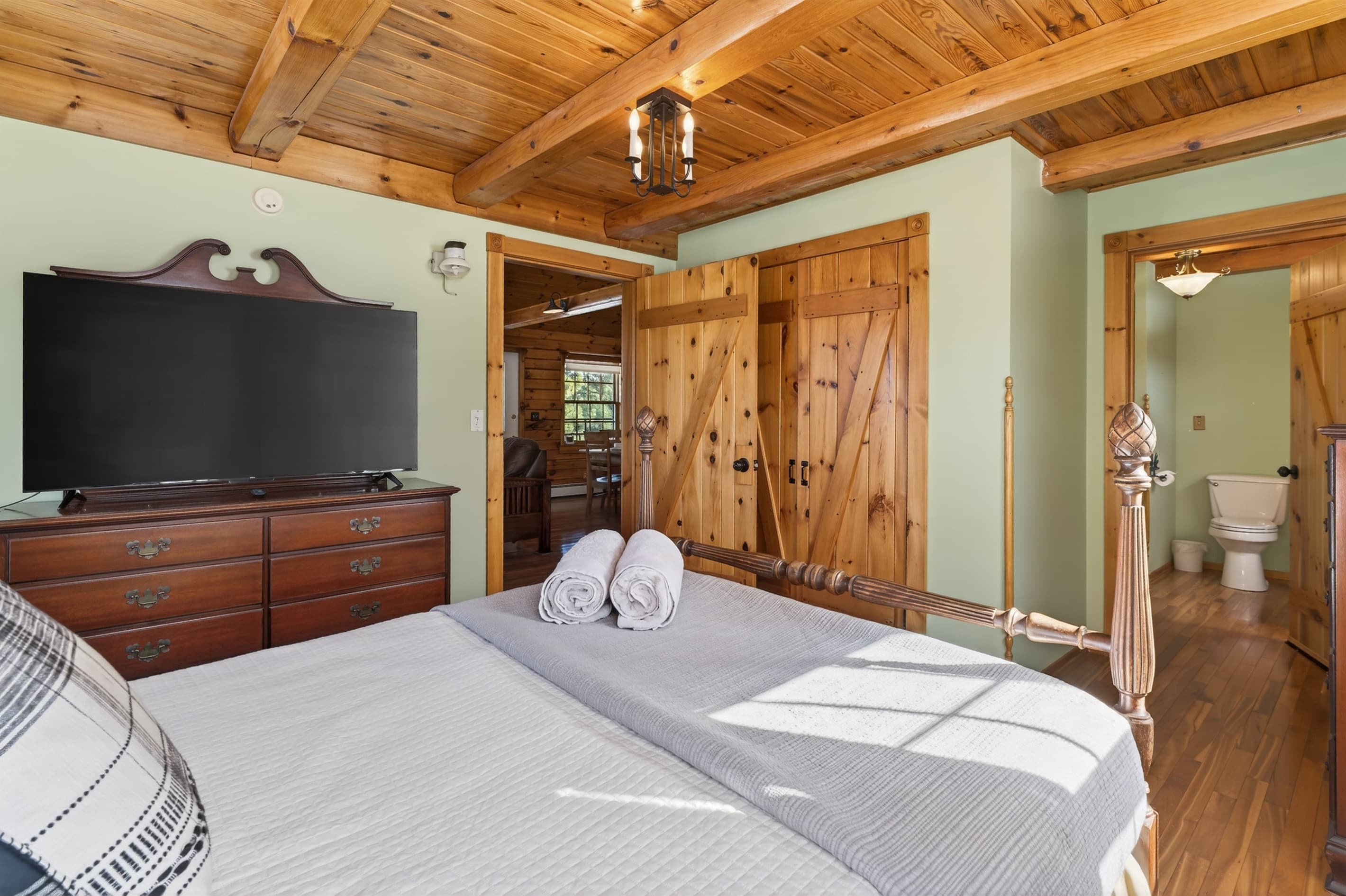 Bedroom with television above wooden dresser