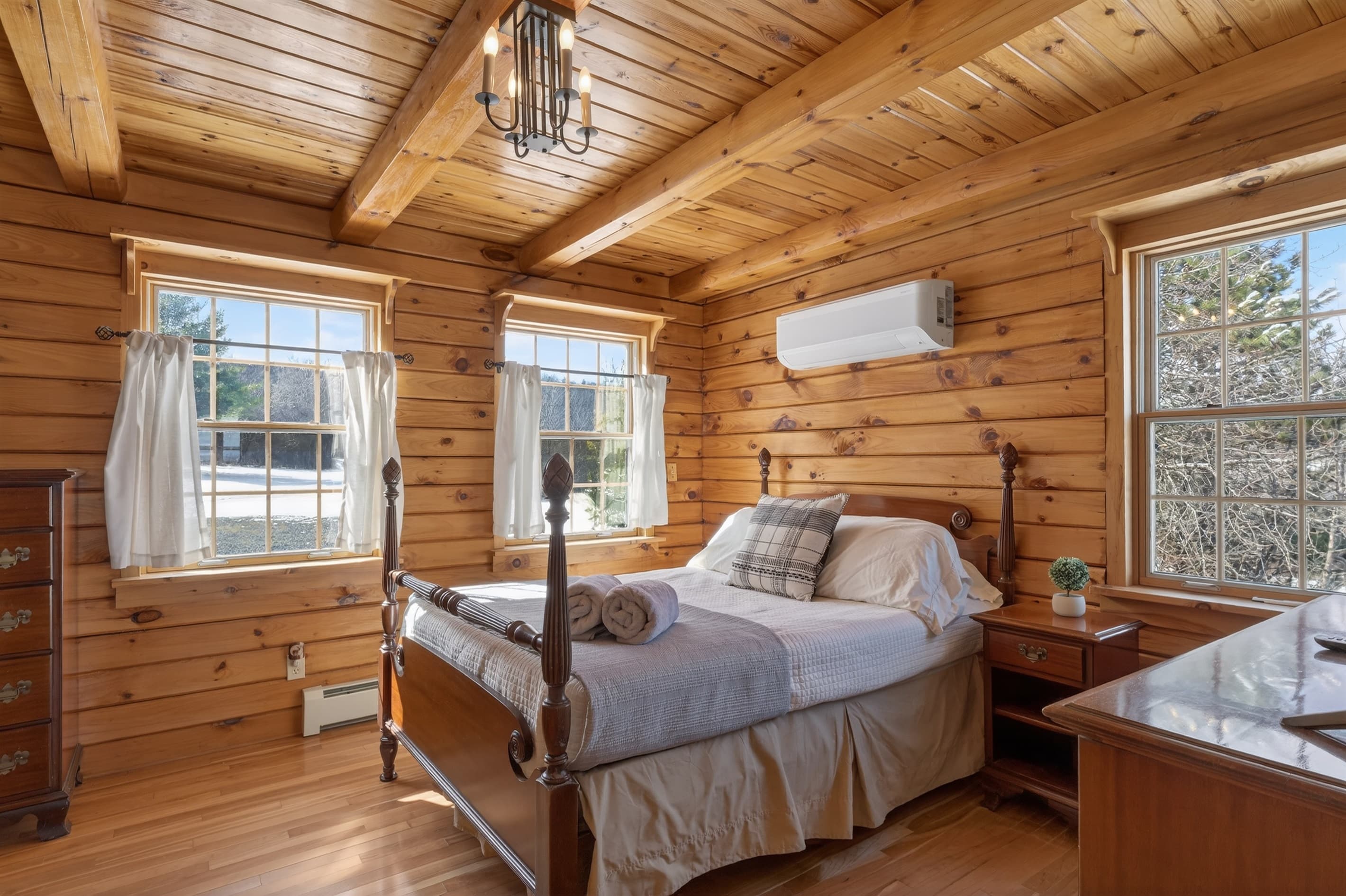 Wood-paneled bedroom with bed and two windows