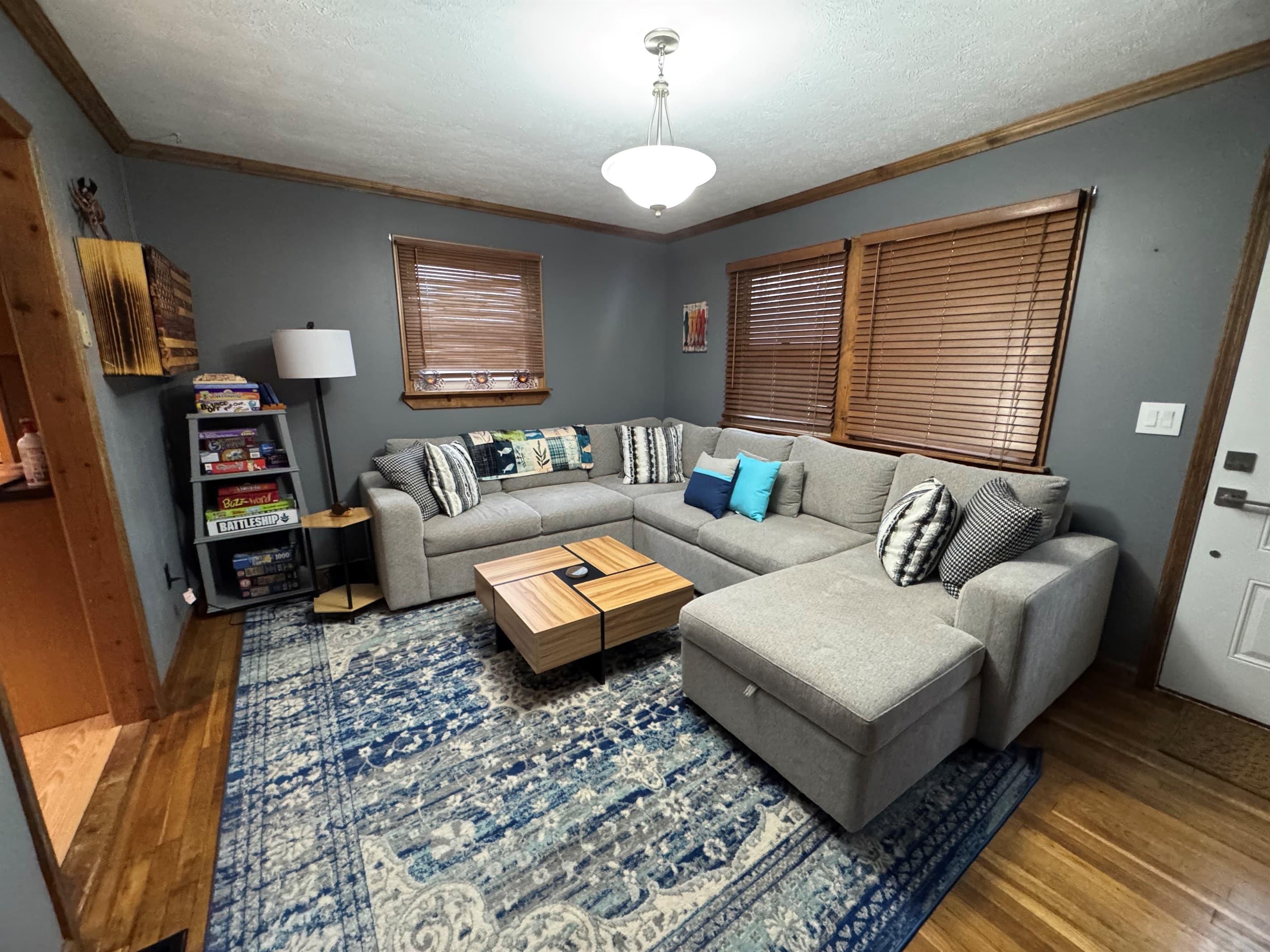 Living room with gray sectional and bookshelves