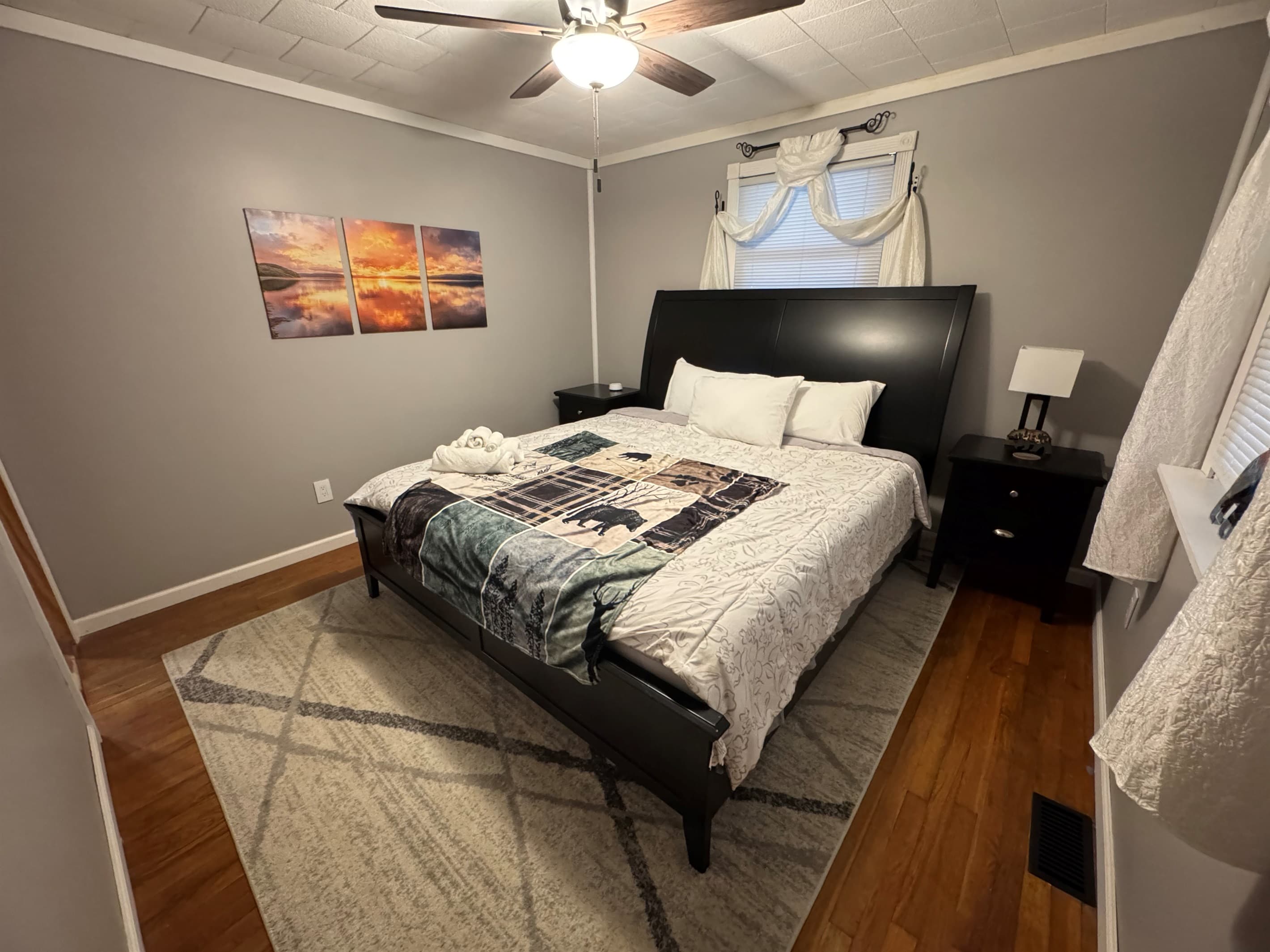 Bedroom with black headboard and ceiling fan