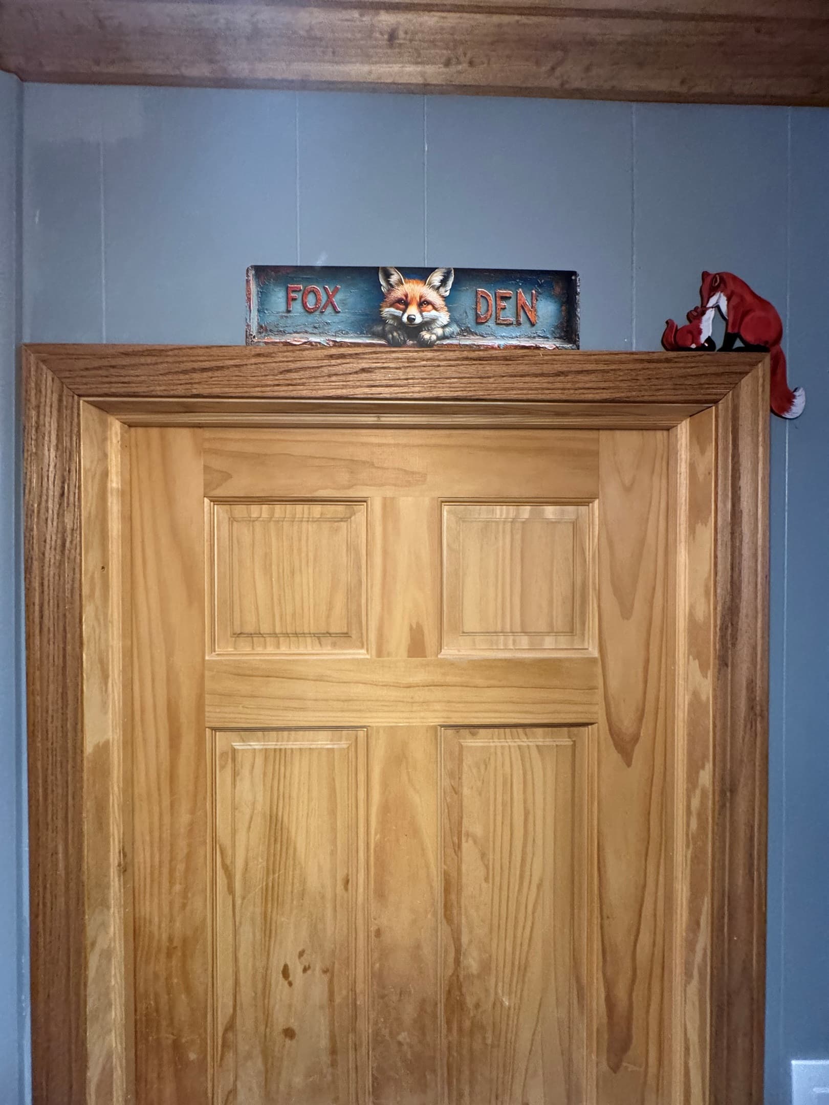 Wooden cabinet beneath a decorative sign