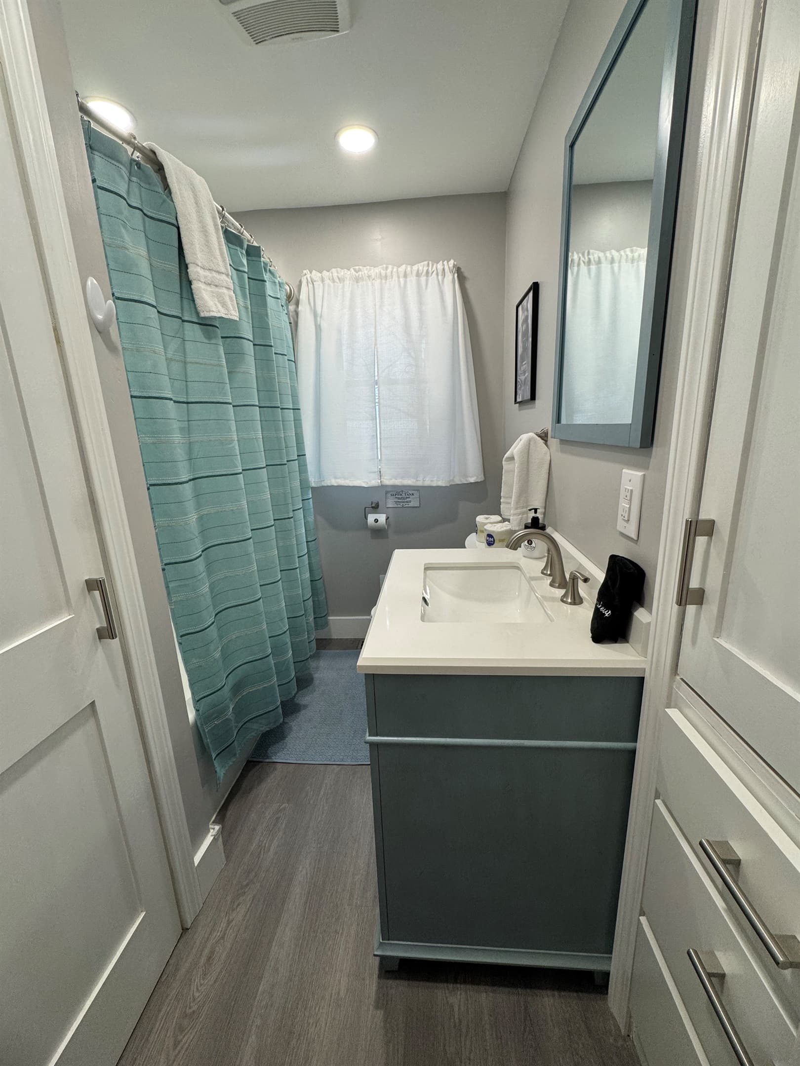 Bathroom vanity beside teal shower curtain