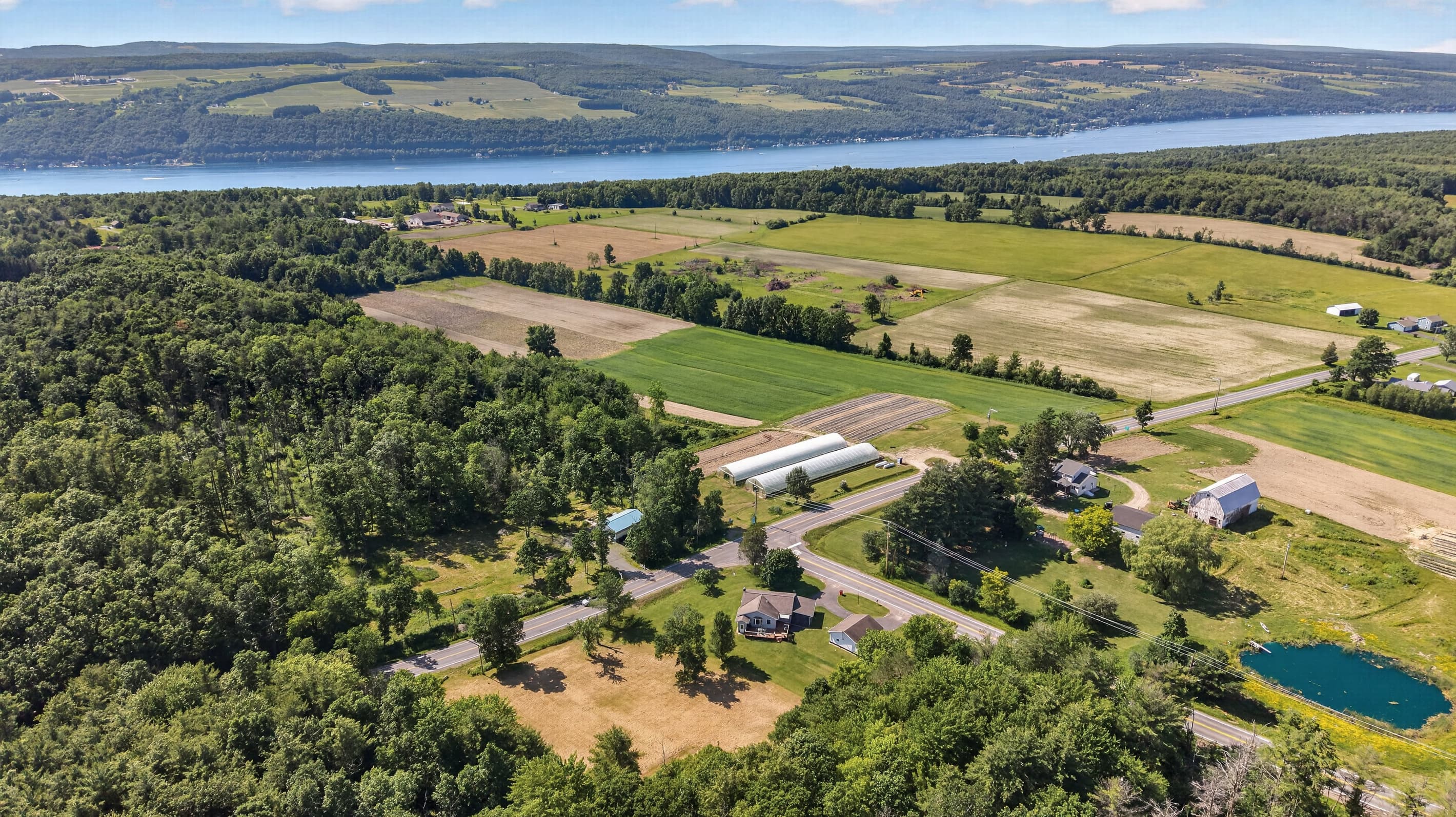 Aerial landscape with fields, pond, and lake