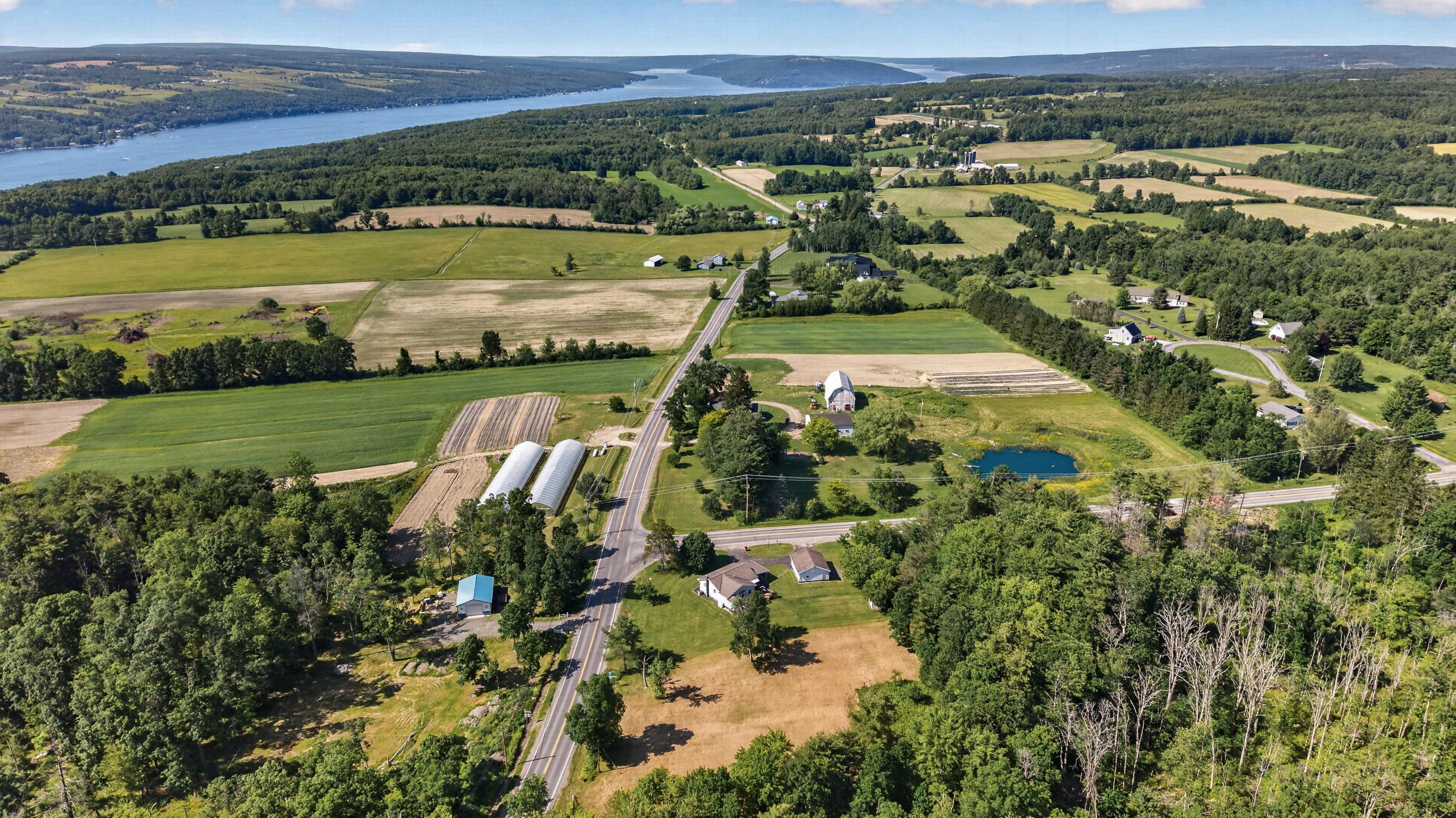 Greenhouses surrounded by fields and woodland