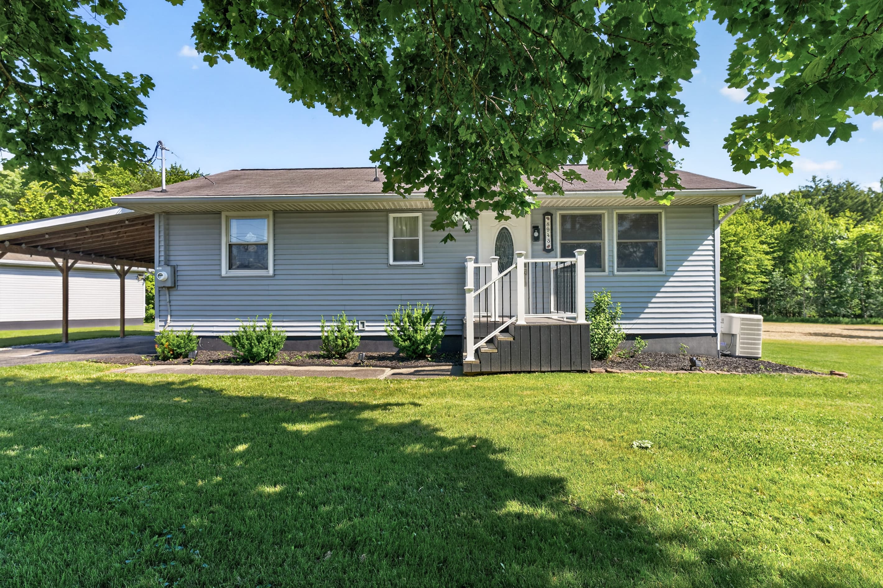 Front exterior shaded by a mature tree