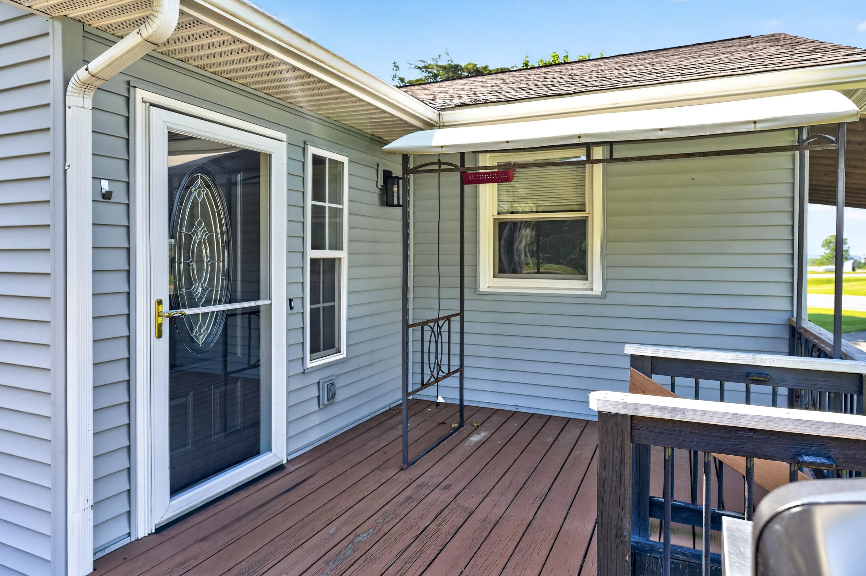 Decorative front door beside wooden deck railing