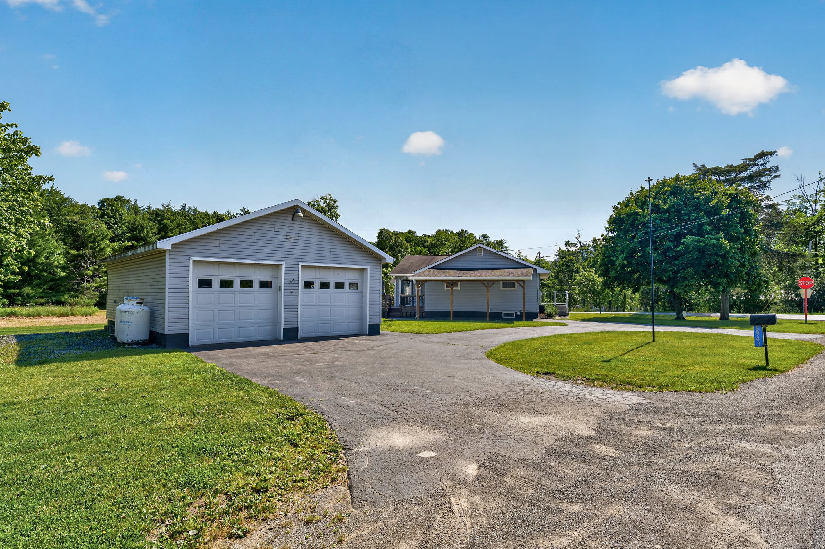 Garage and paved driveway beneath clear skies