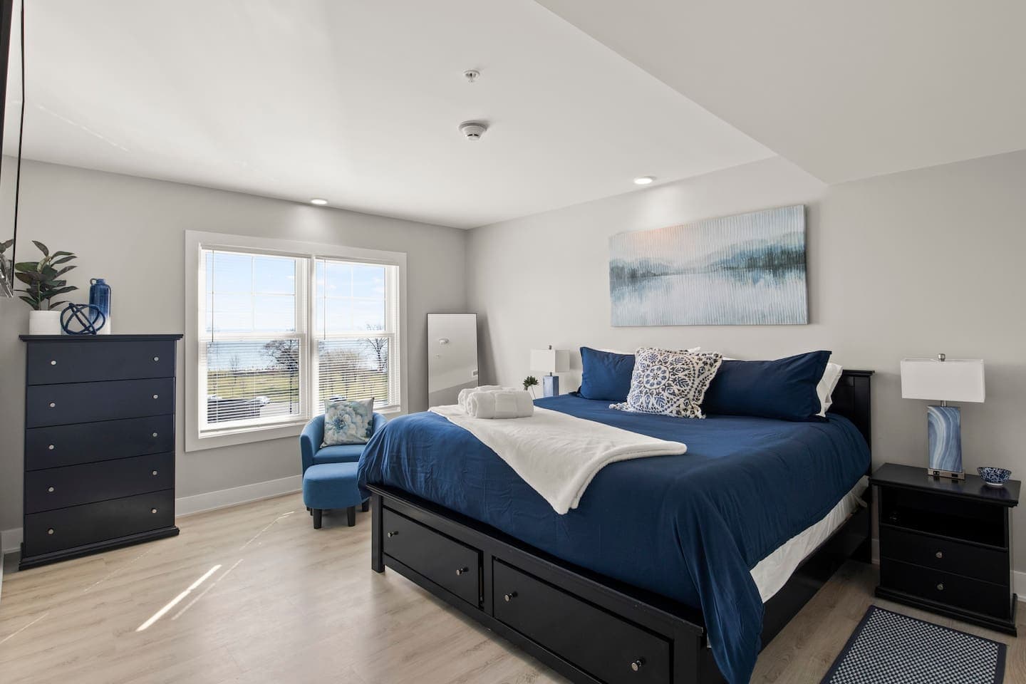 Bedroom with blue bedding and mounted television