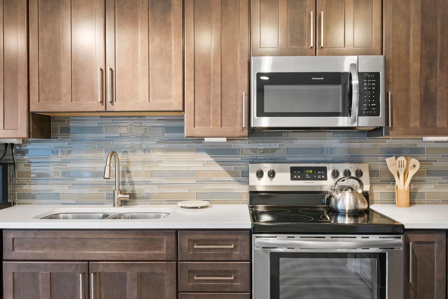 Kitchen with wood cabinetry and stone counters