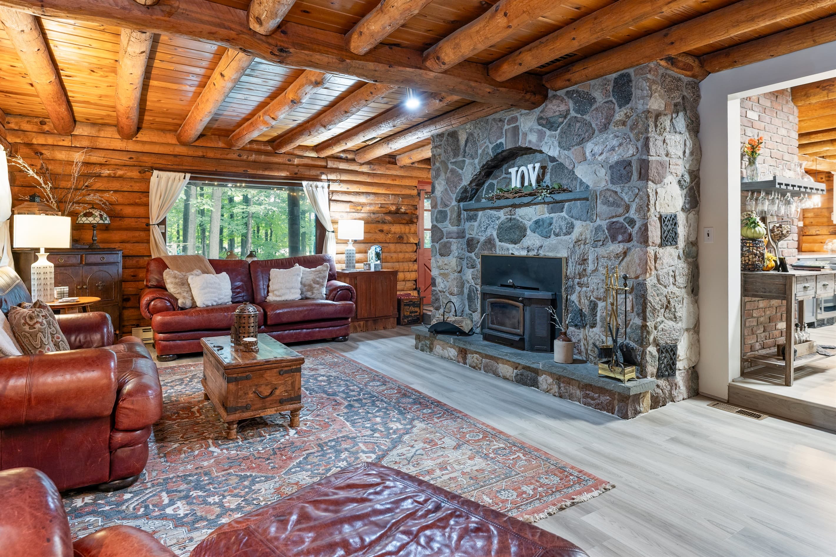 Living room with stone fireplace and wood ceiling