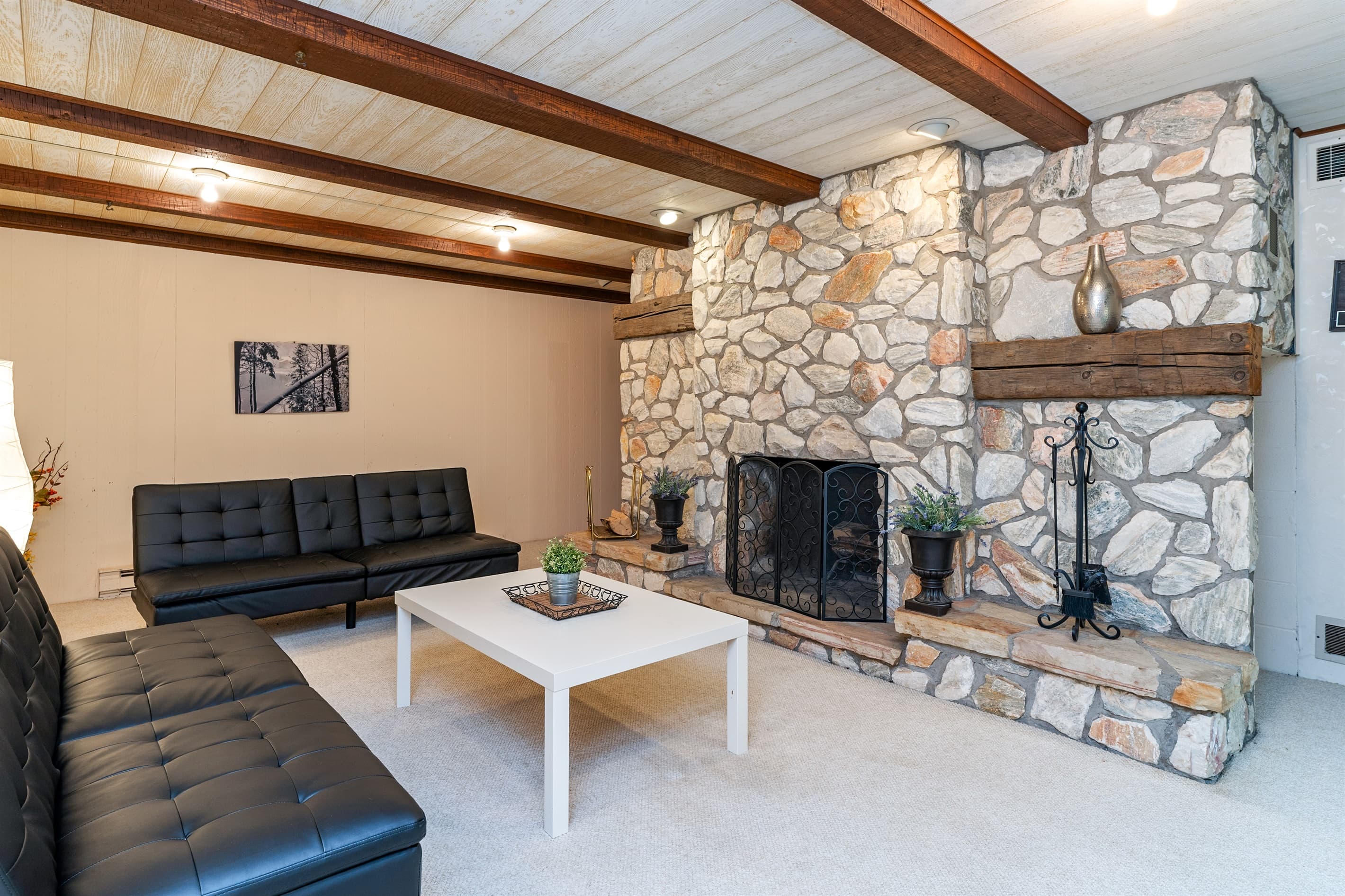 Lower-level living room with stone fireplace