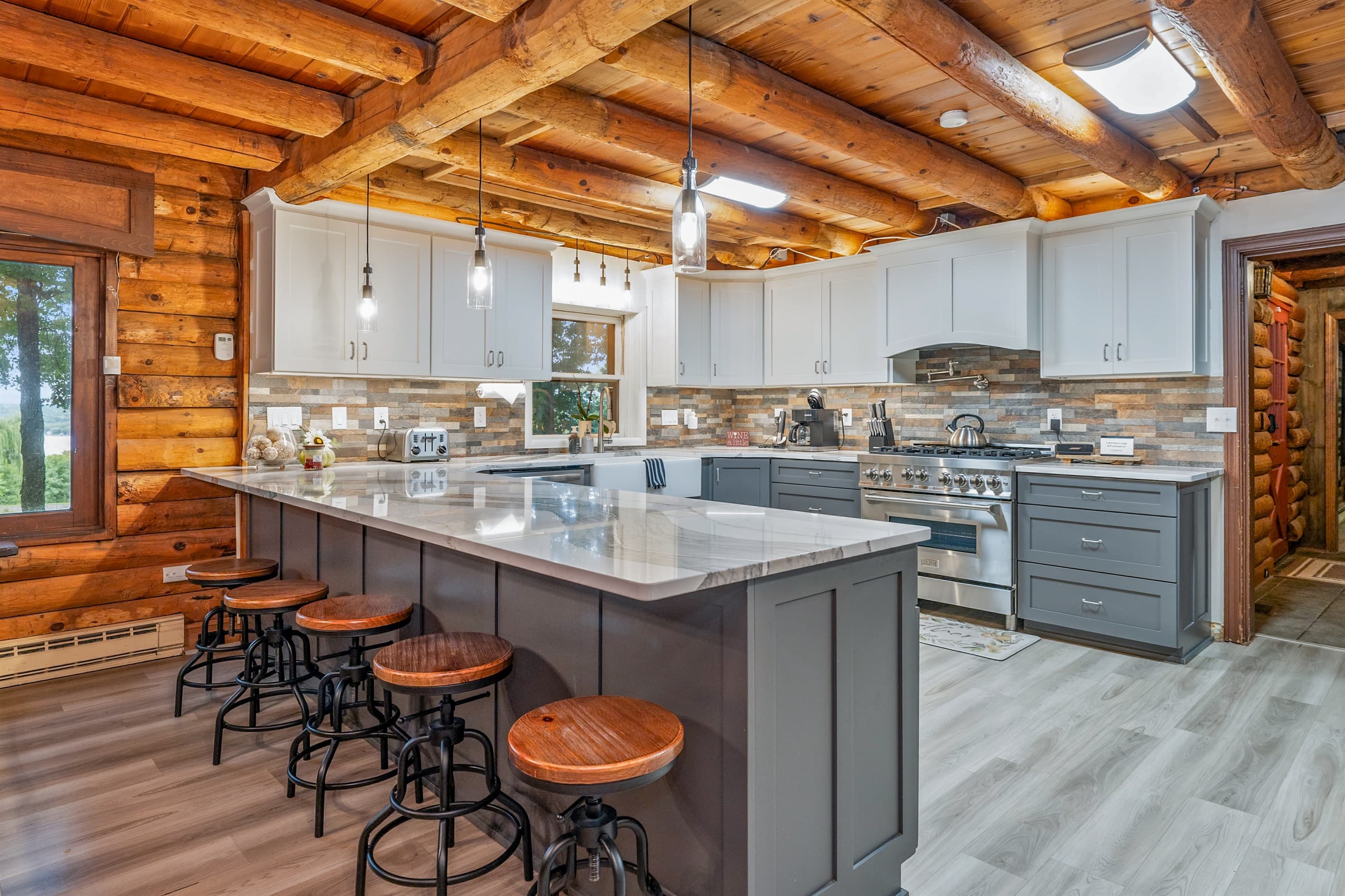 Farmhouse kitchen with stone backsplash and grey cabinetry