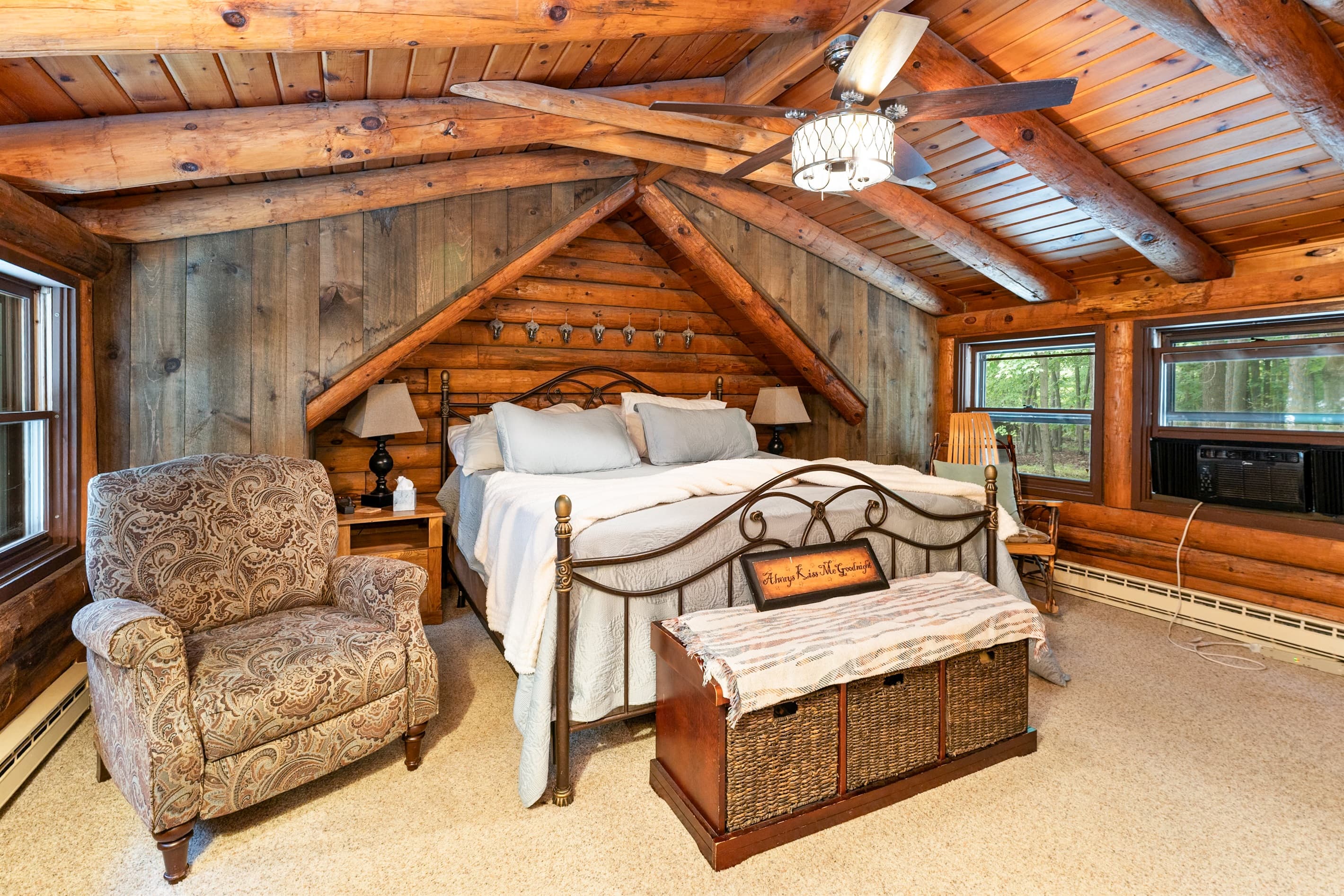 Wood-paneled bedroom with bed and lounge chair