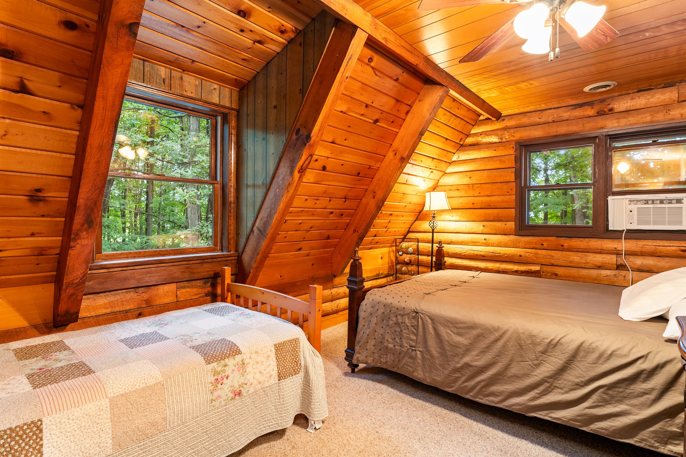 Wood-paneled bedroom with queen and twin beds