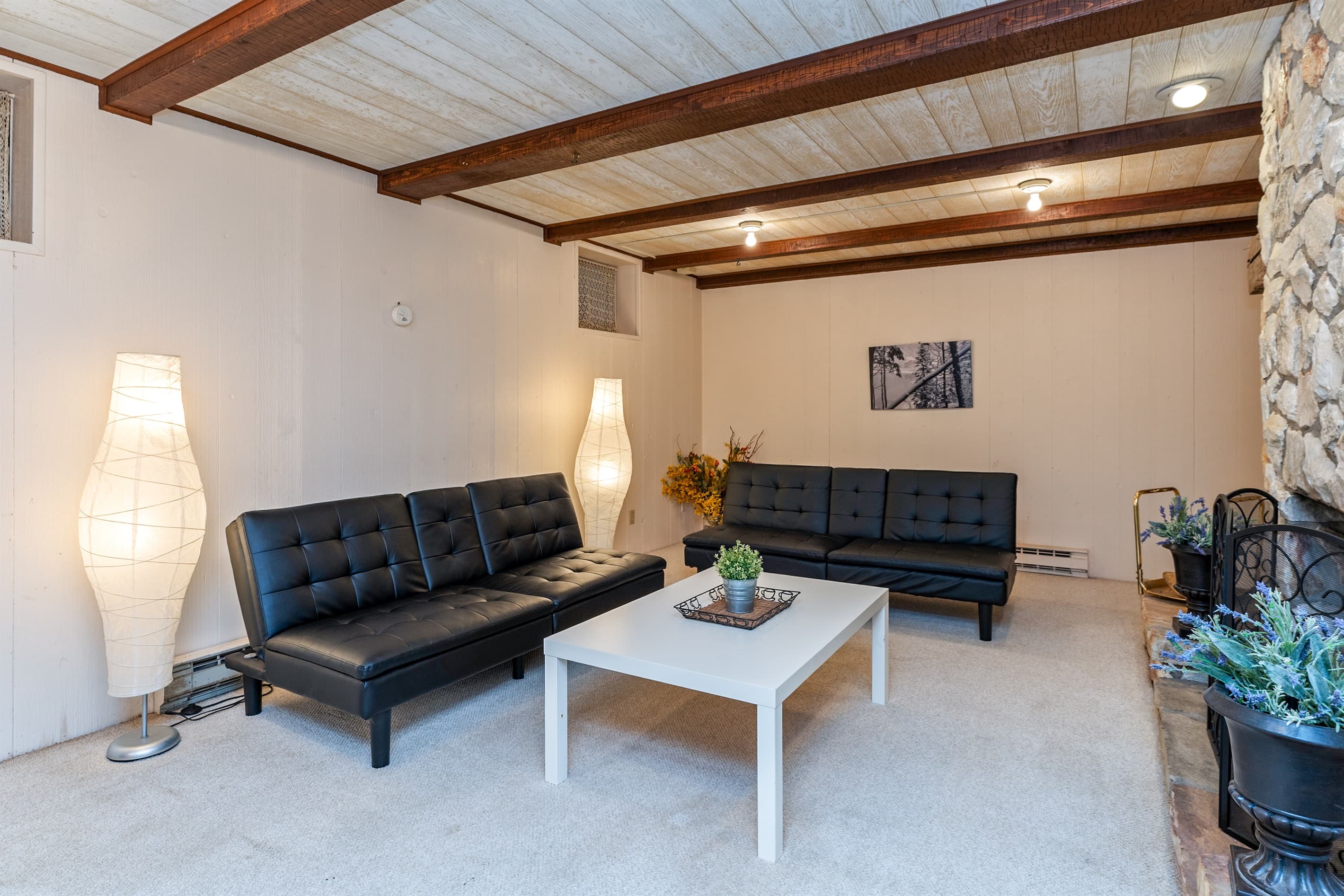 Lower-level lounge with sectional and stone fireplace