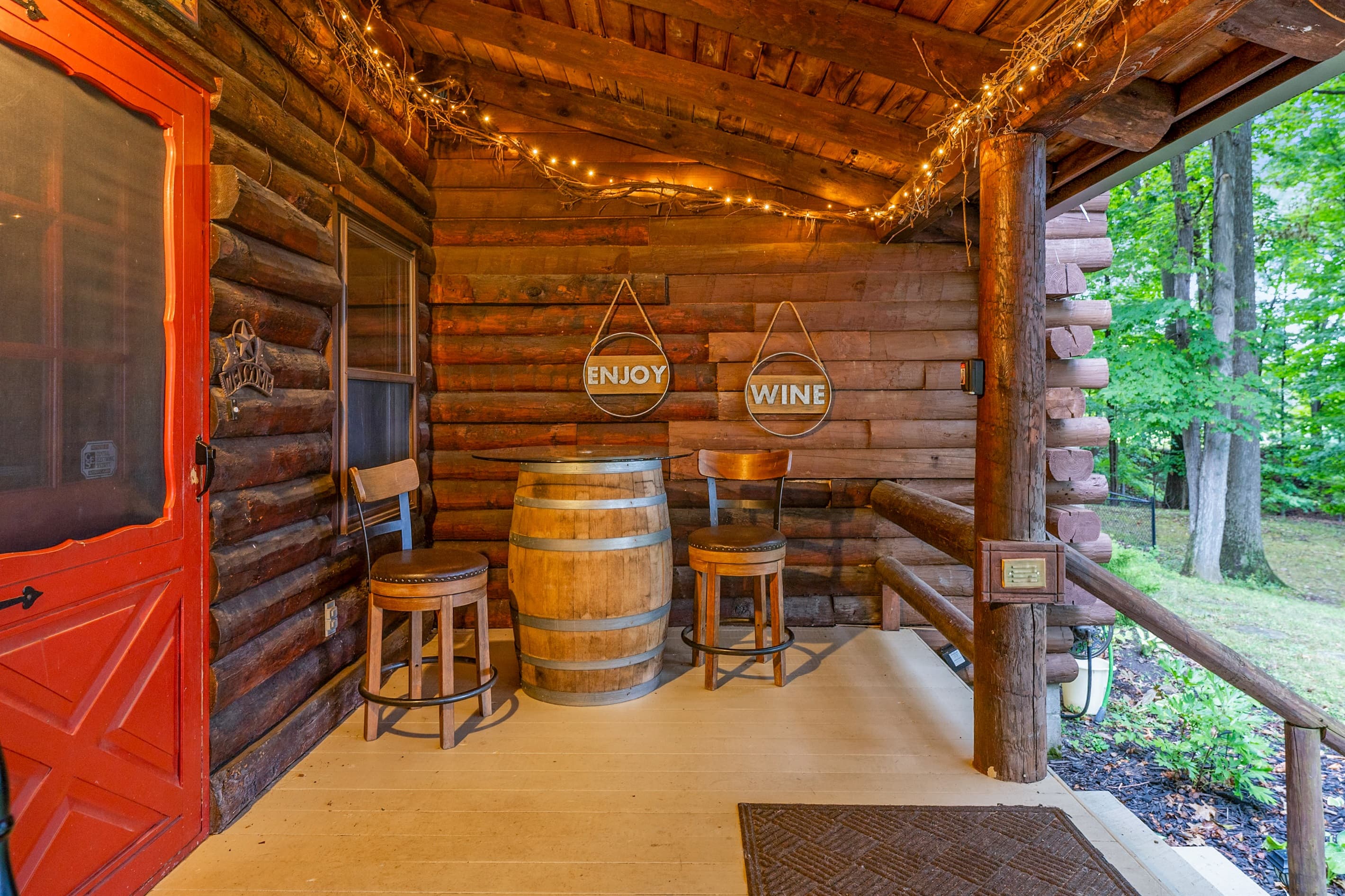 Covered porch with outdoor barrel table and string lights