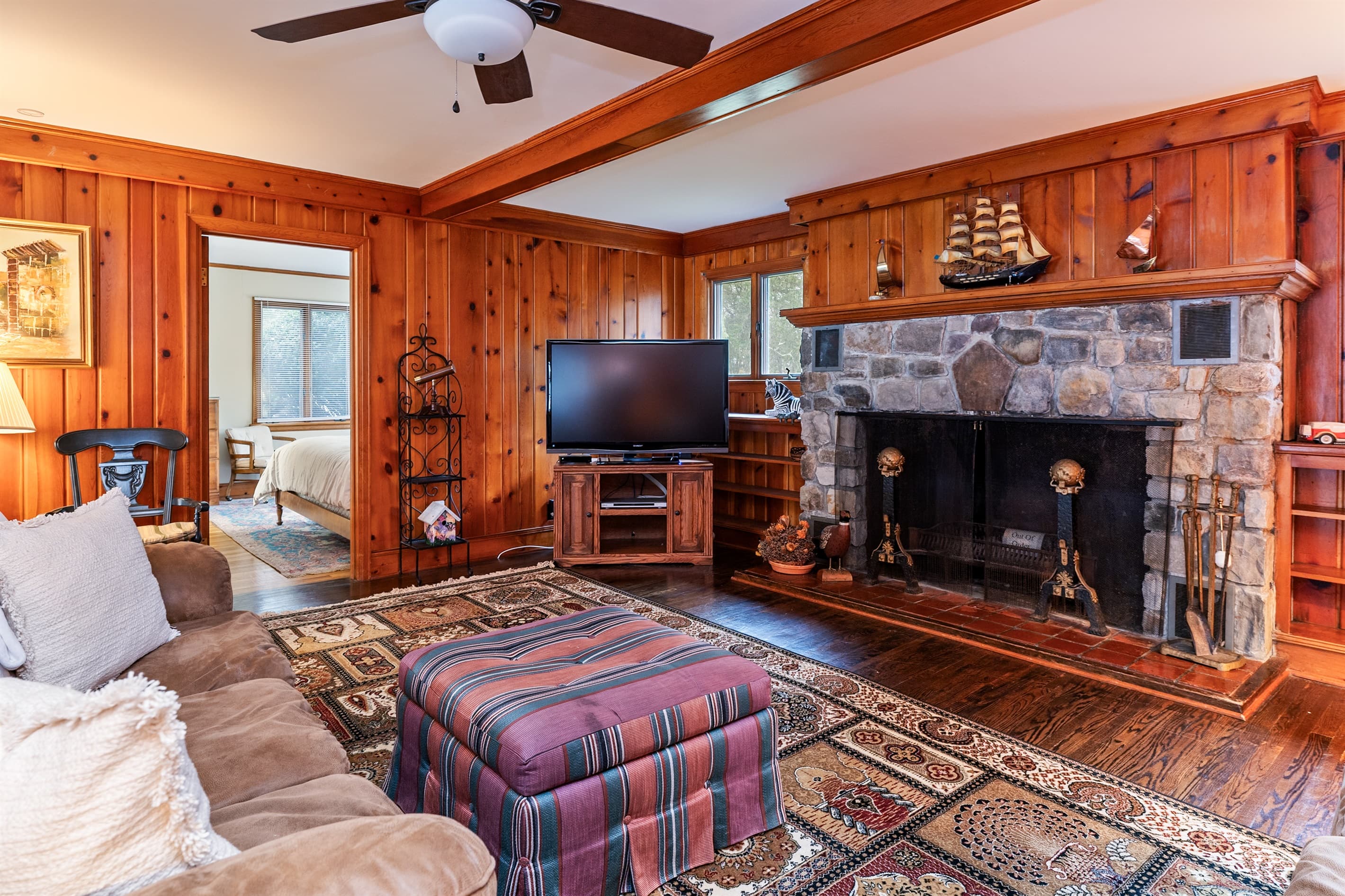 Wood-paneled living room with television and sectional