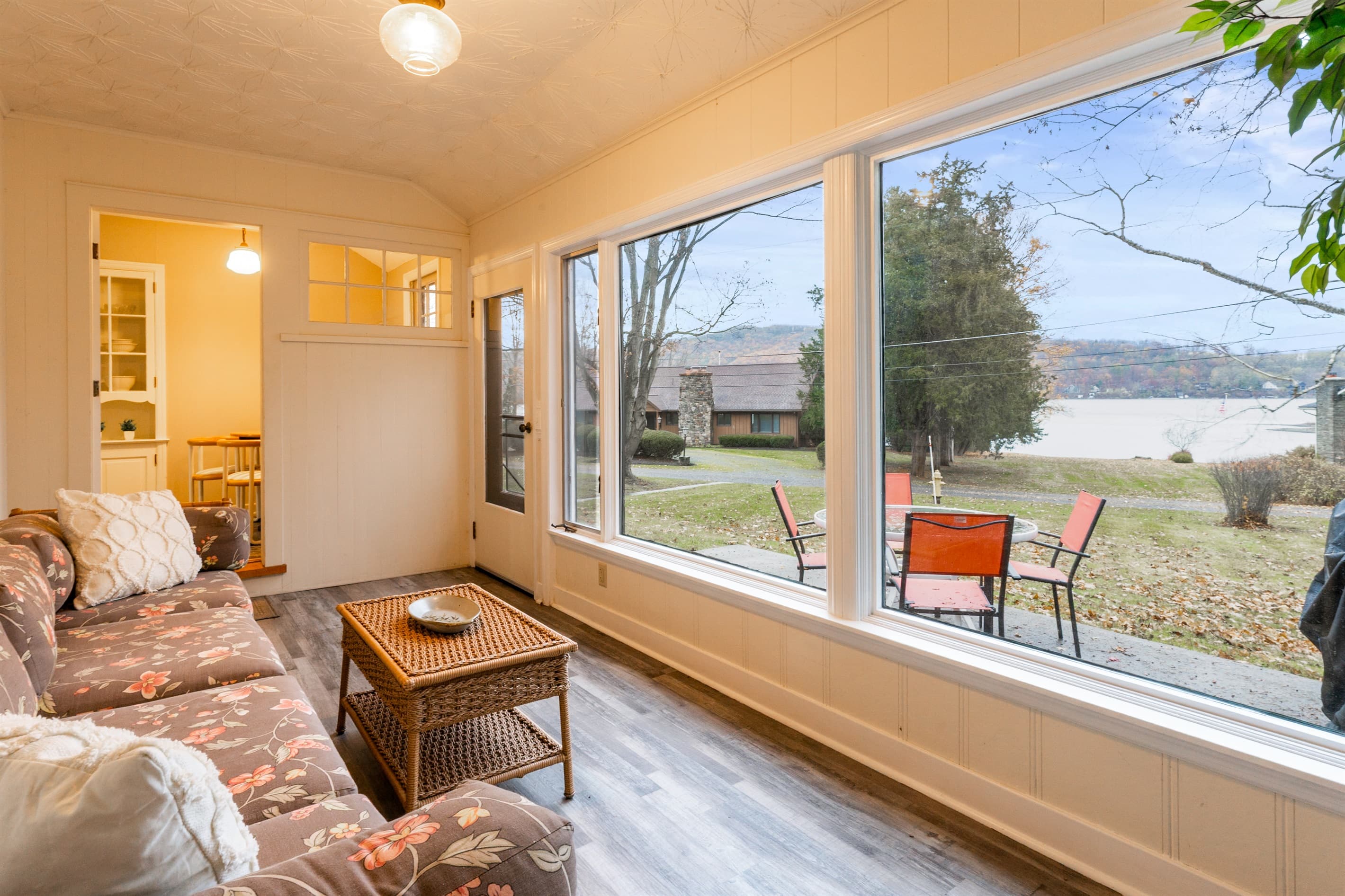 Sunroom seating beside large windows with lake view