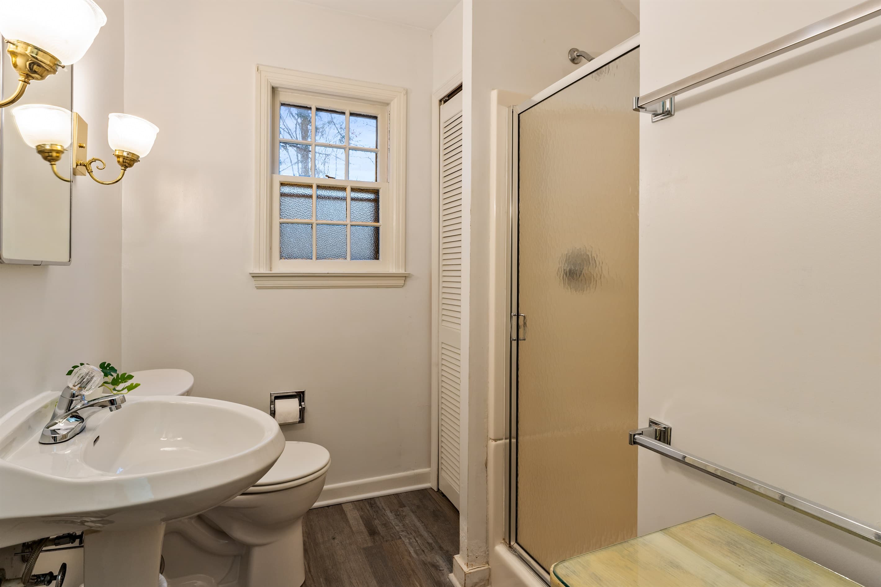 Full bathroom with toilet and glass enclosed shower