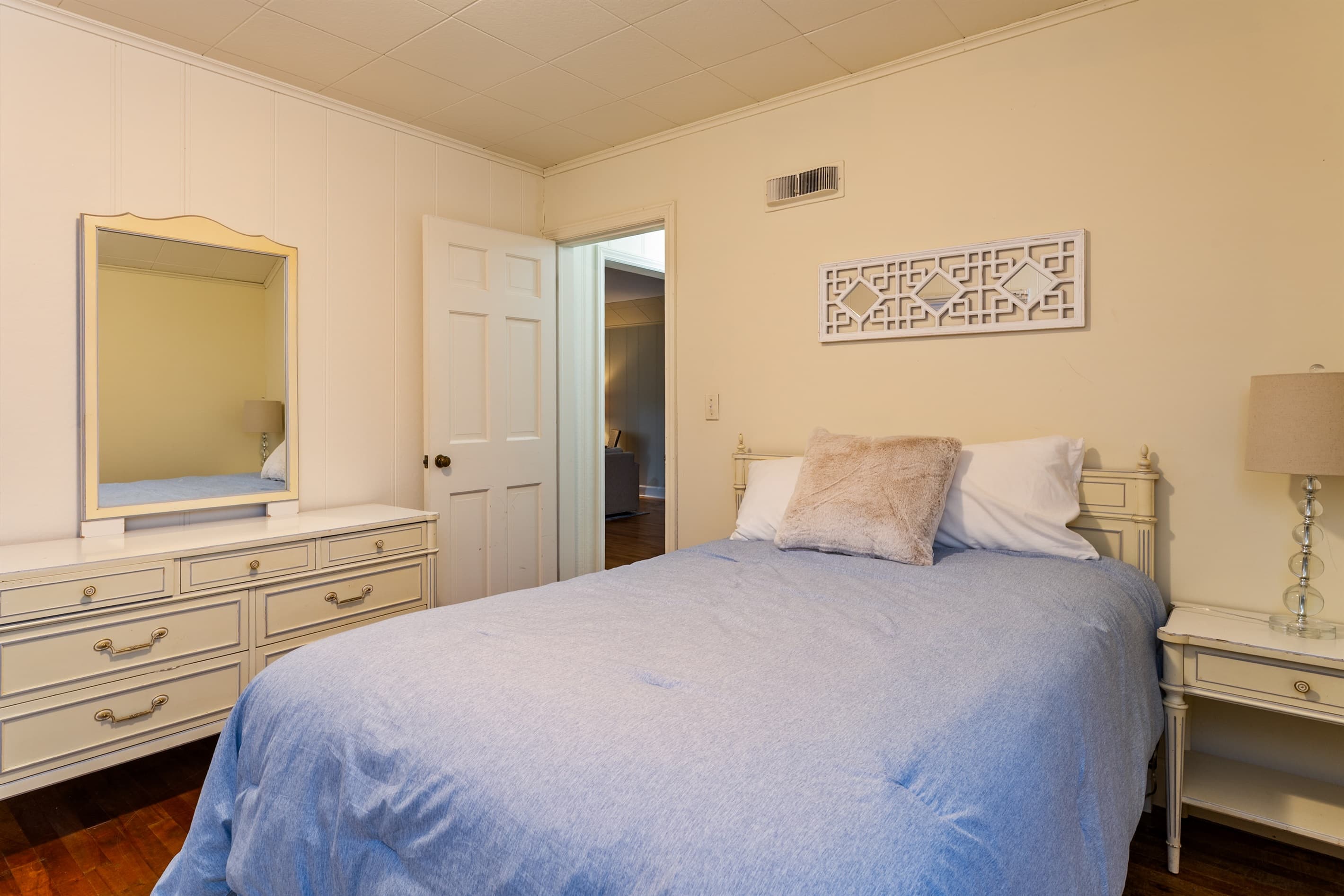 Queen bedroom with white dresser and nightstands