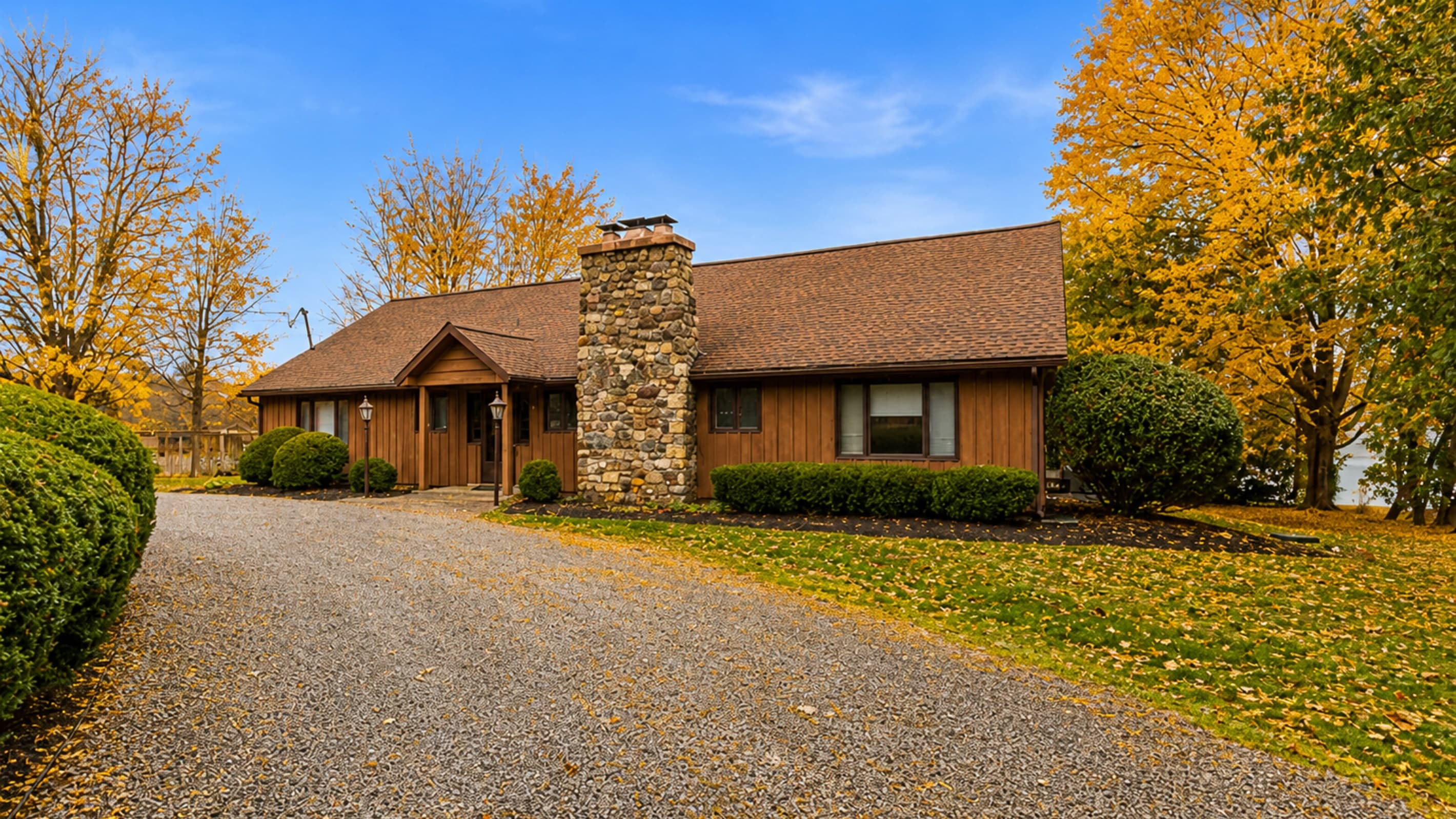 Driveway entrance with prominent stone chimney