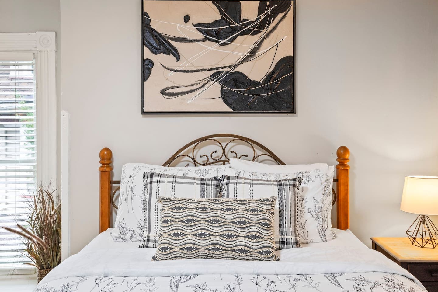 Bedroom with wood and metal bed beneath wall art