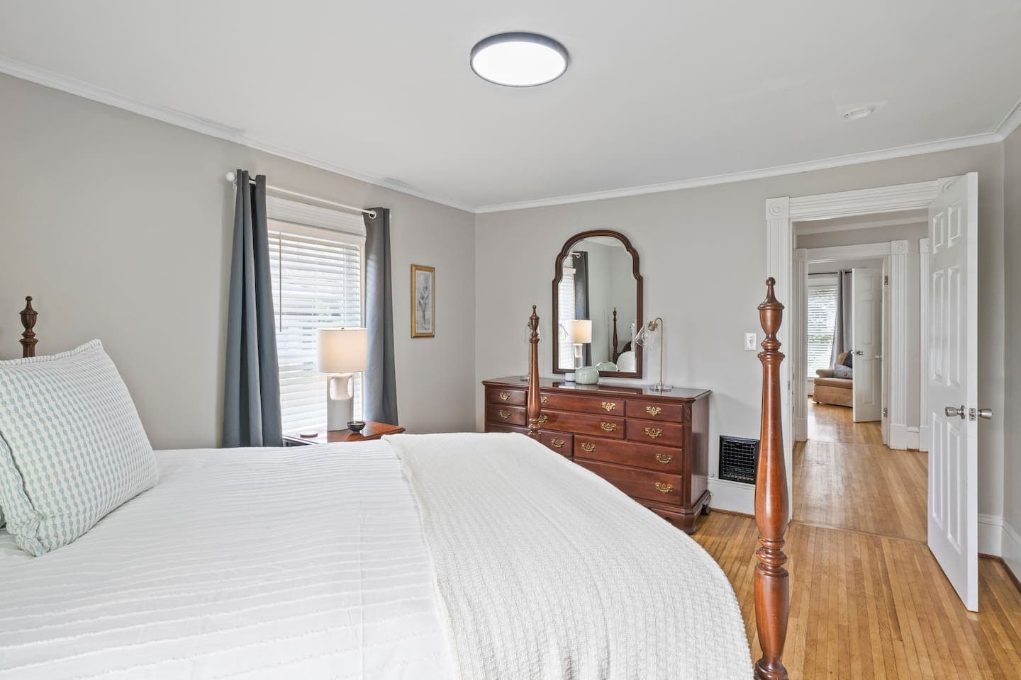 Bedroom with wood dresser and adjoining hallway