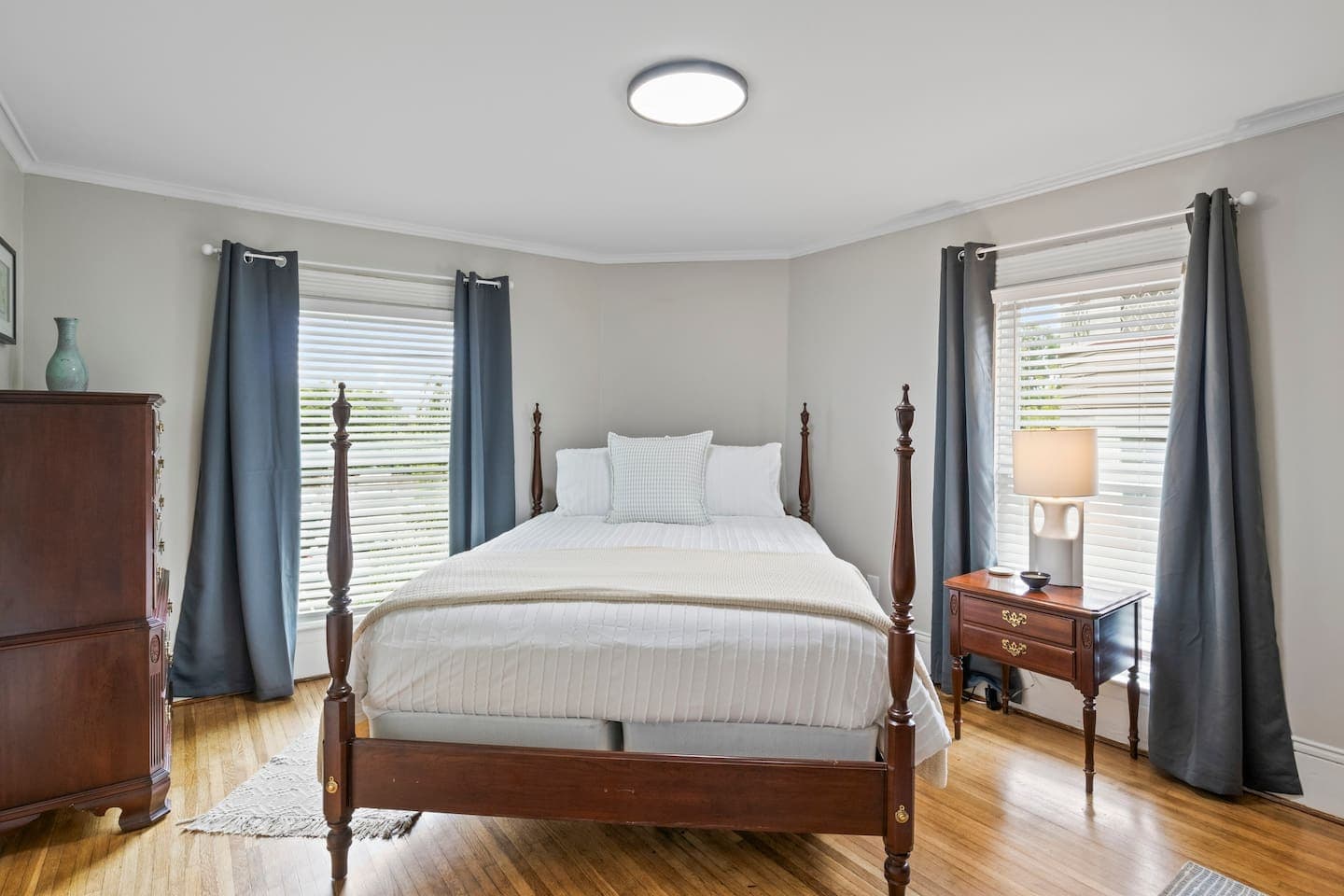Four-poster bed framed by two windows