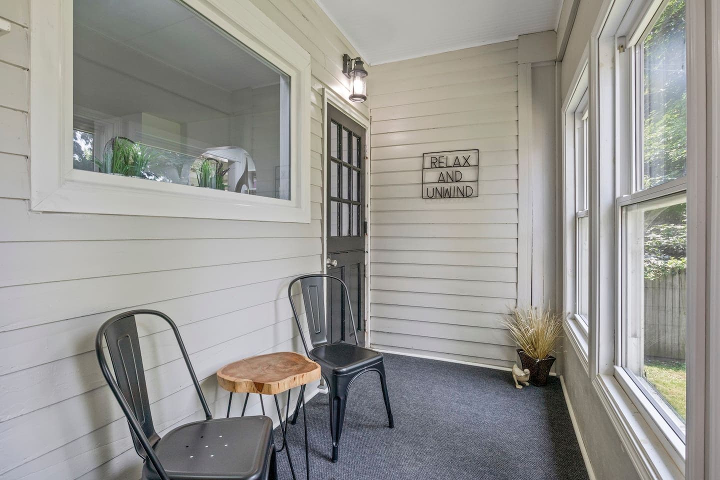 Enclosed porch with wood- paneled wall and seating