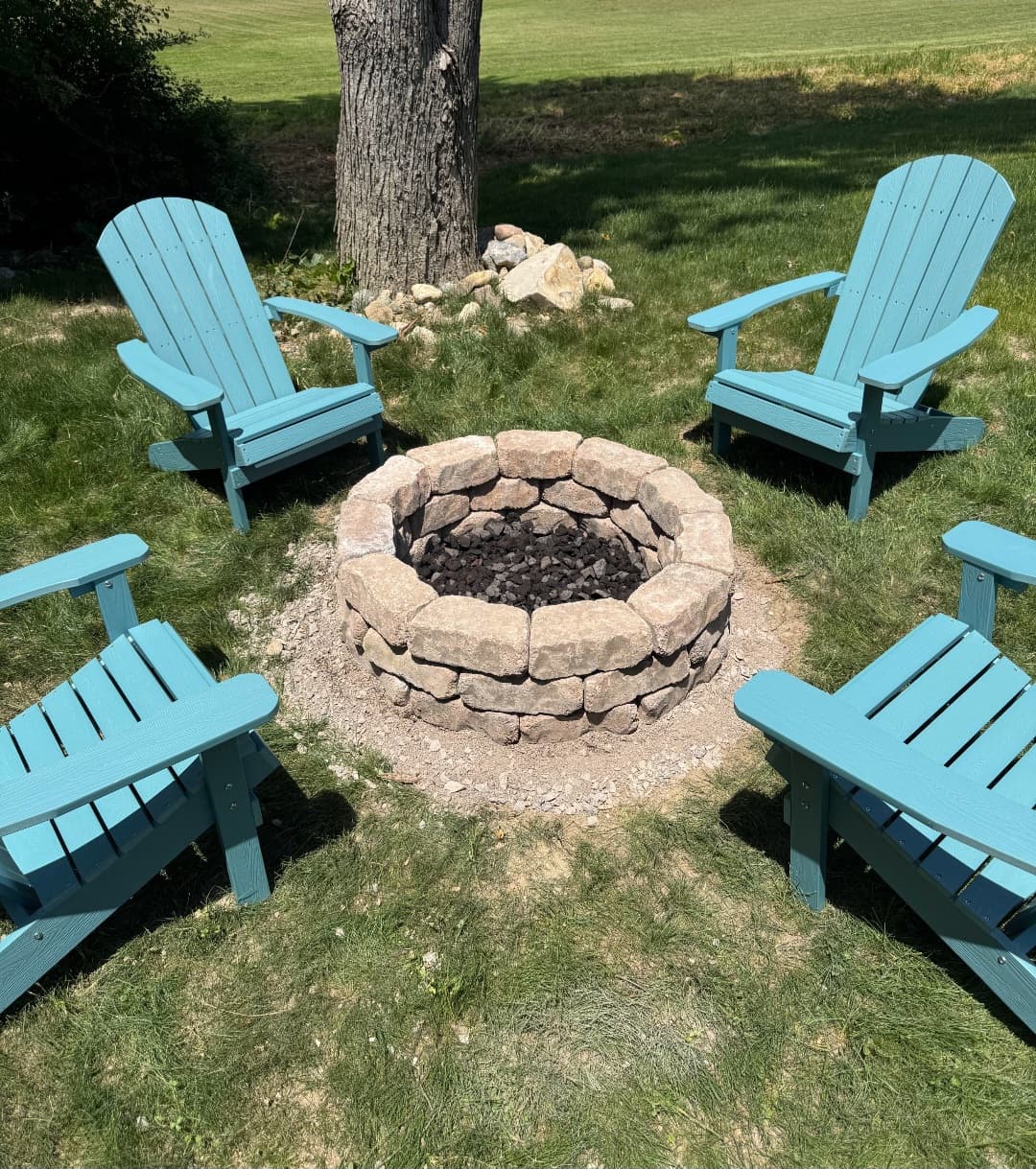 Stone fire pit with Adirondack chairs