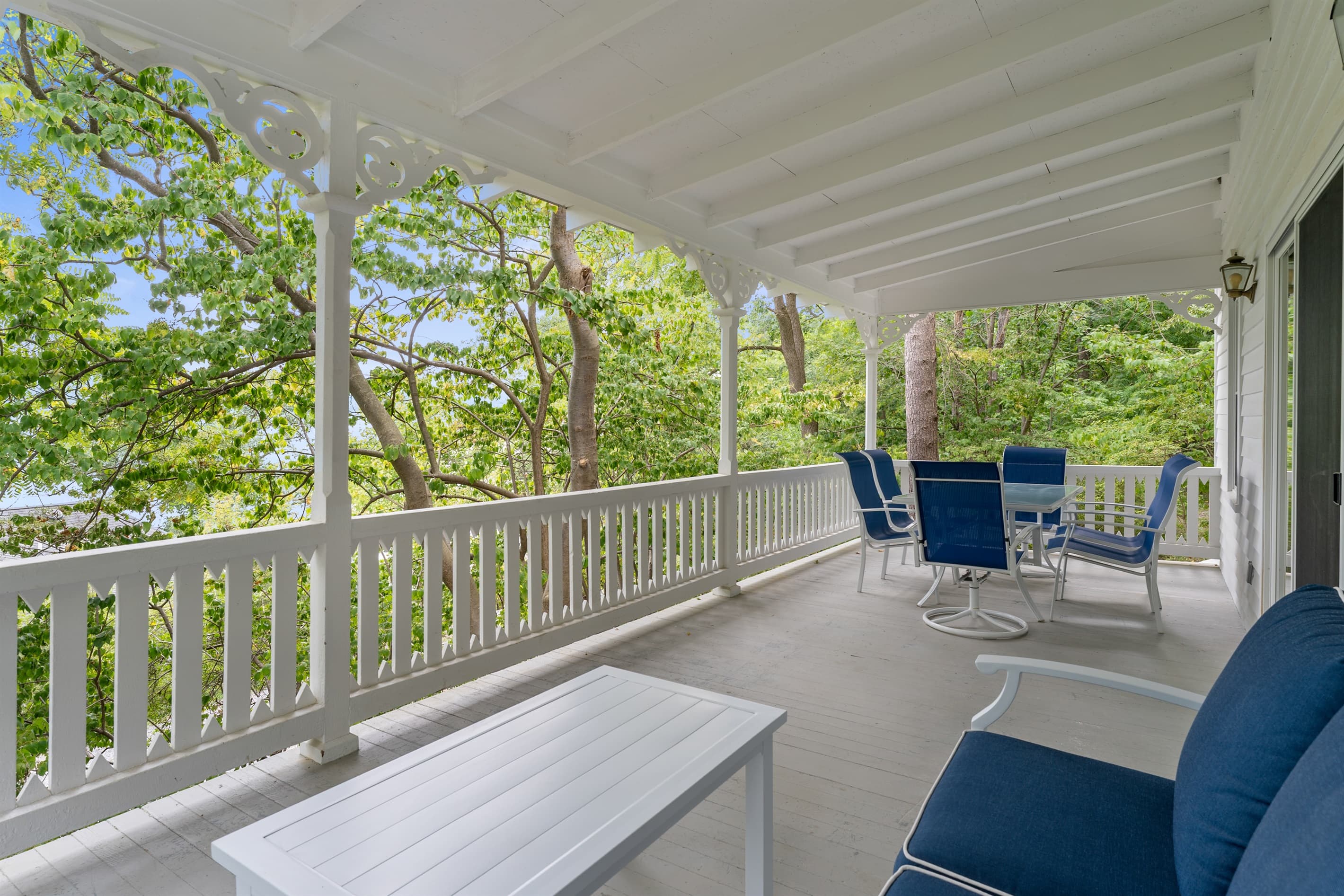 Covered porch with blue cushions on outdoor furniture