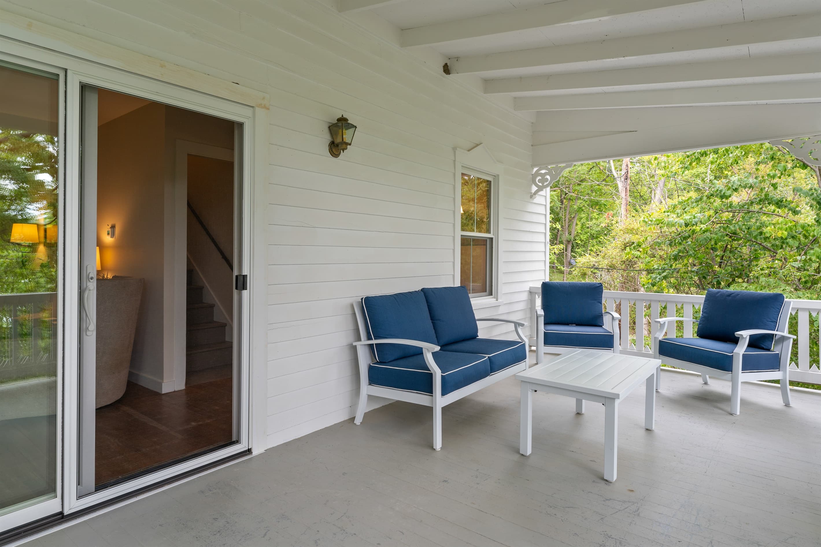 Shaded porch seating beside indoor entrance