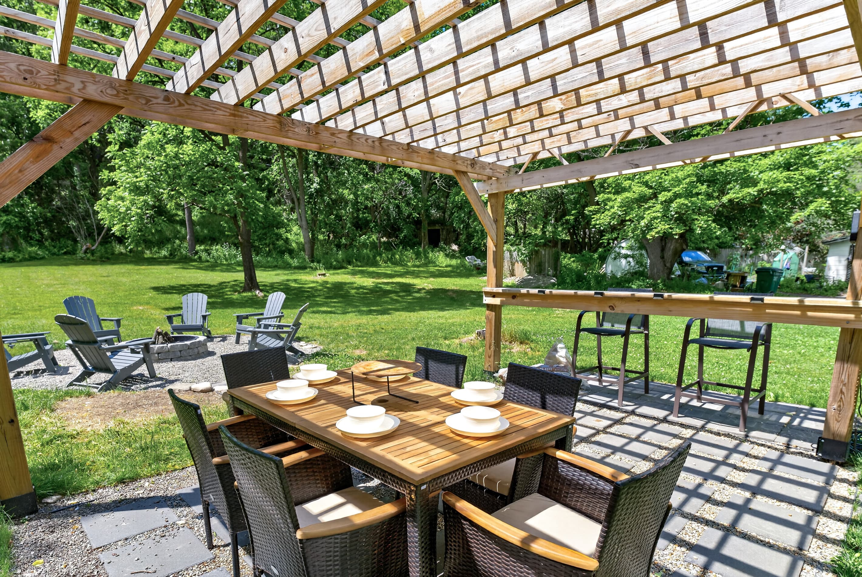 Pergola-covered dining area beside the fire pit