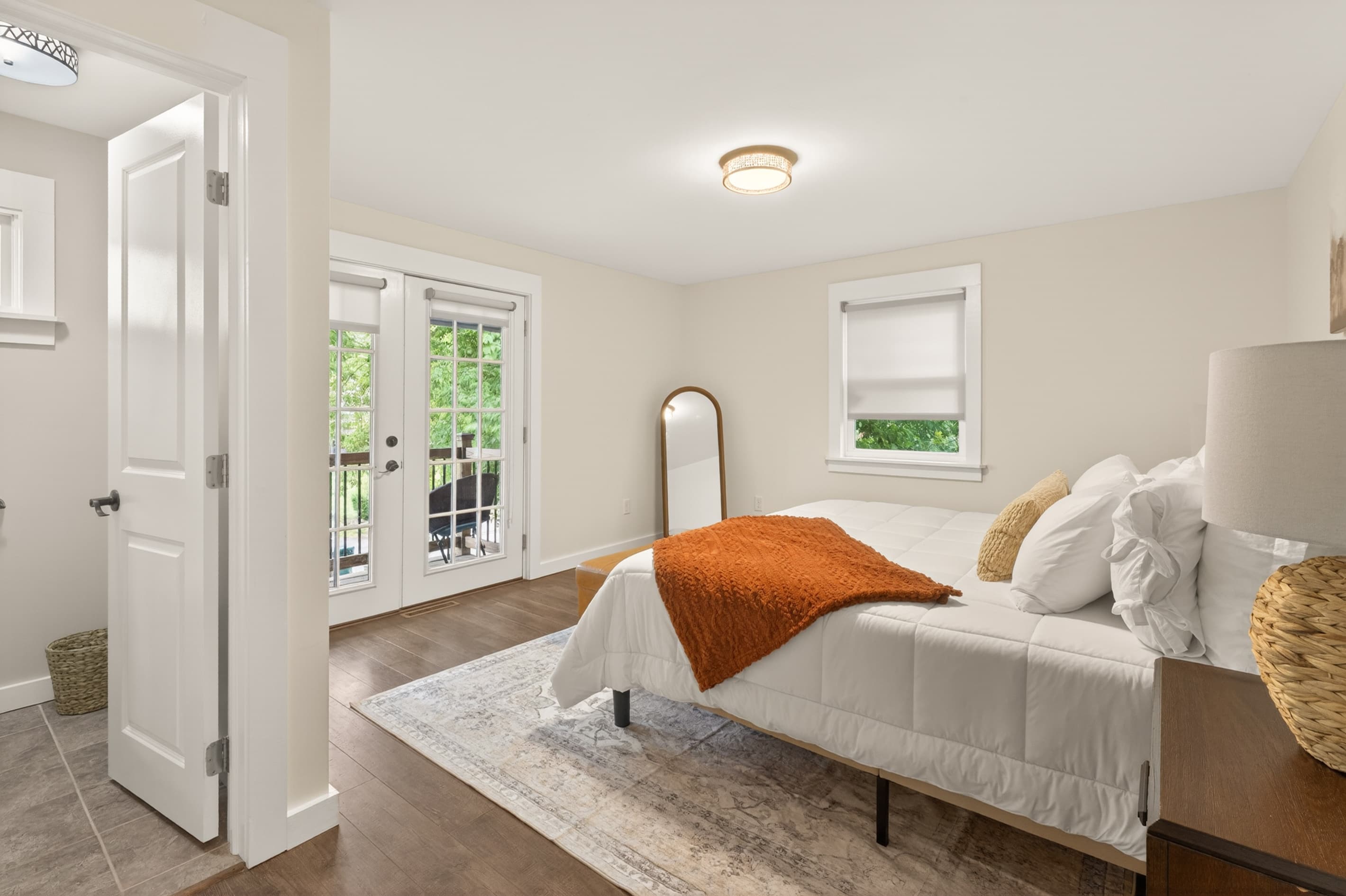Bedroom with orange throw and French doors