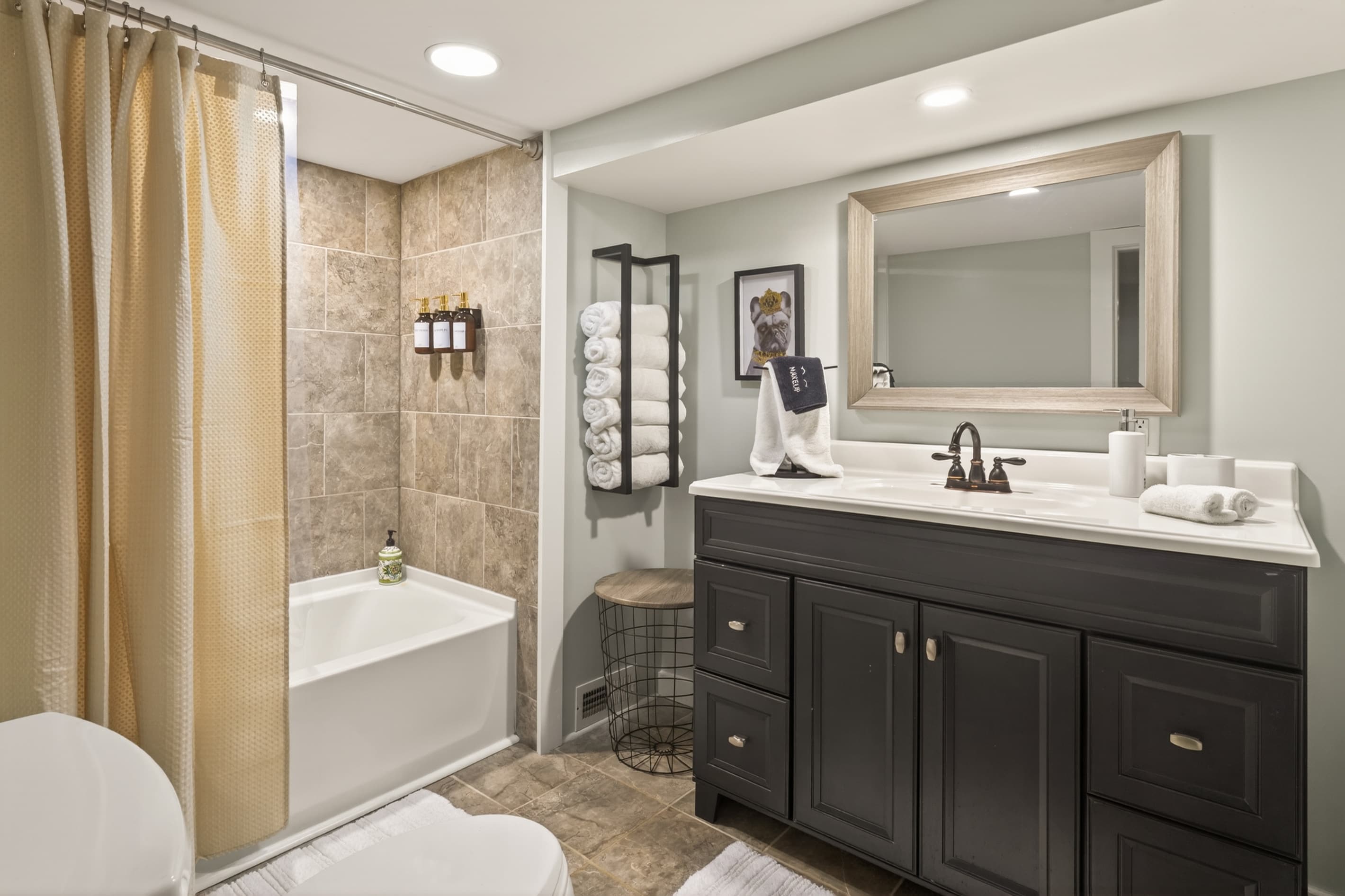 Bathroom with bathtub and black vanity