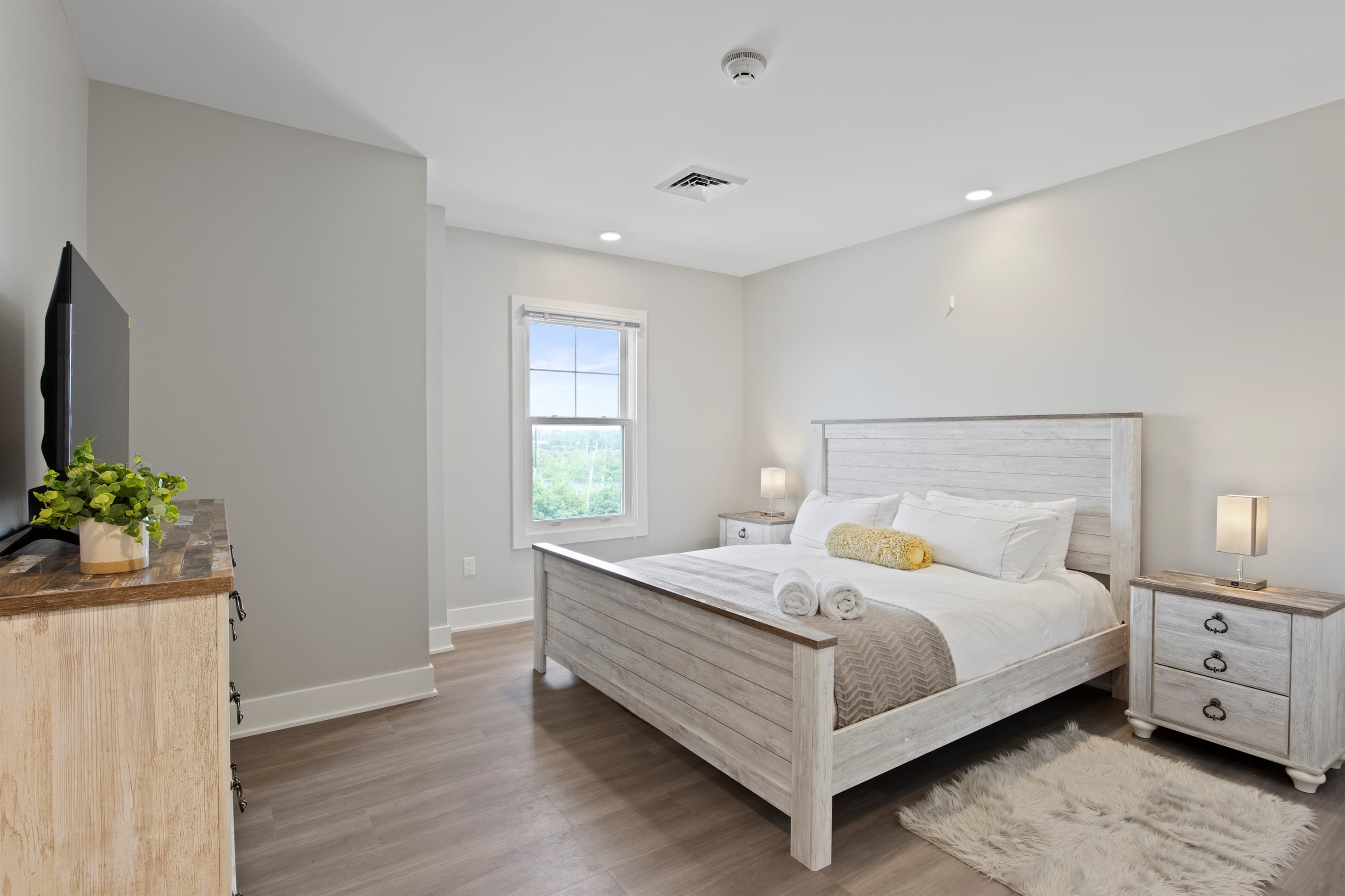 Bedroom with white wooden bed and wall-mounted television