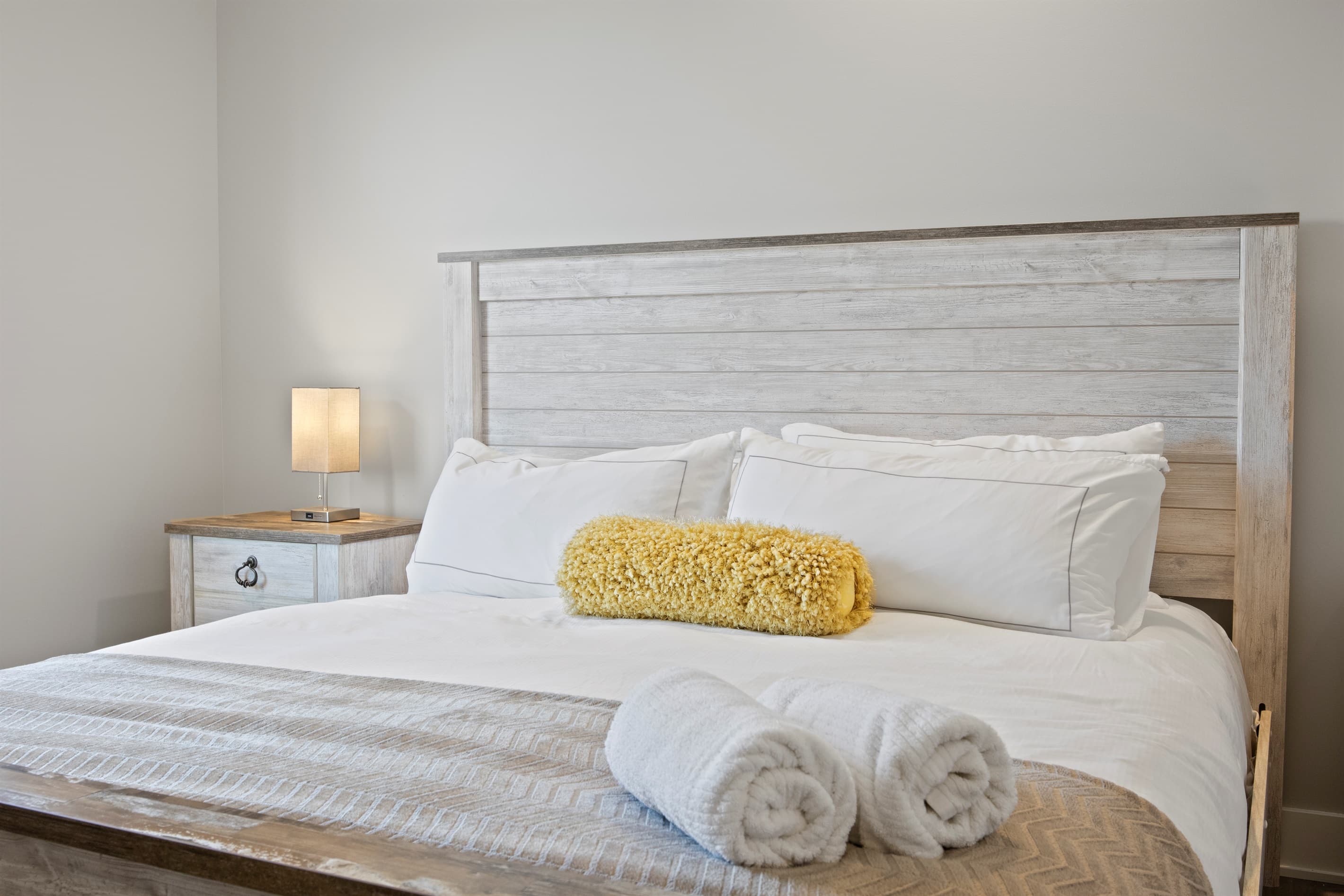 Bedroom with light wood bed frame and yellow accents